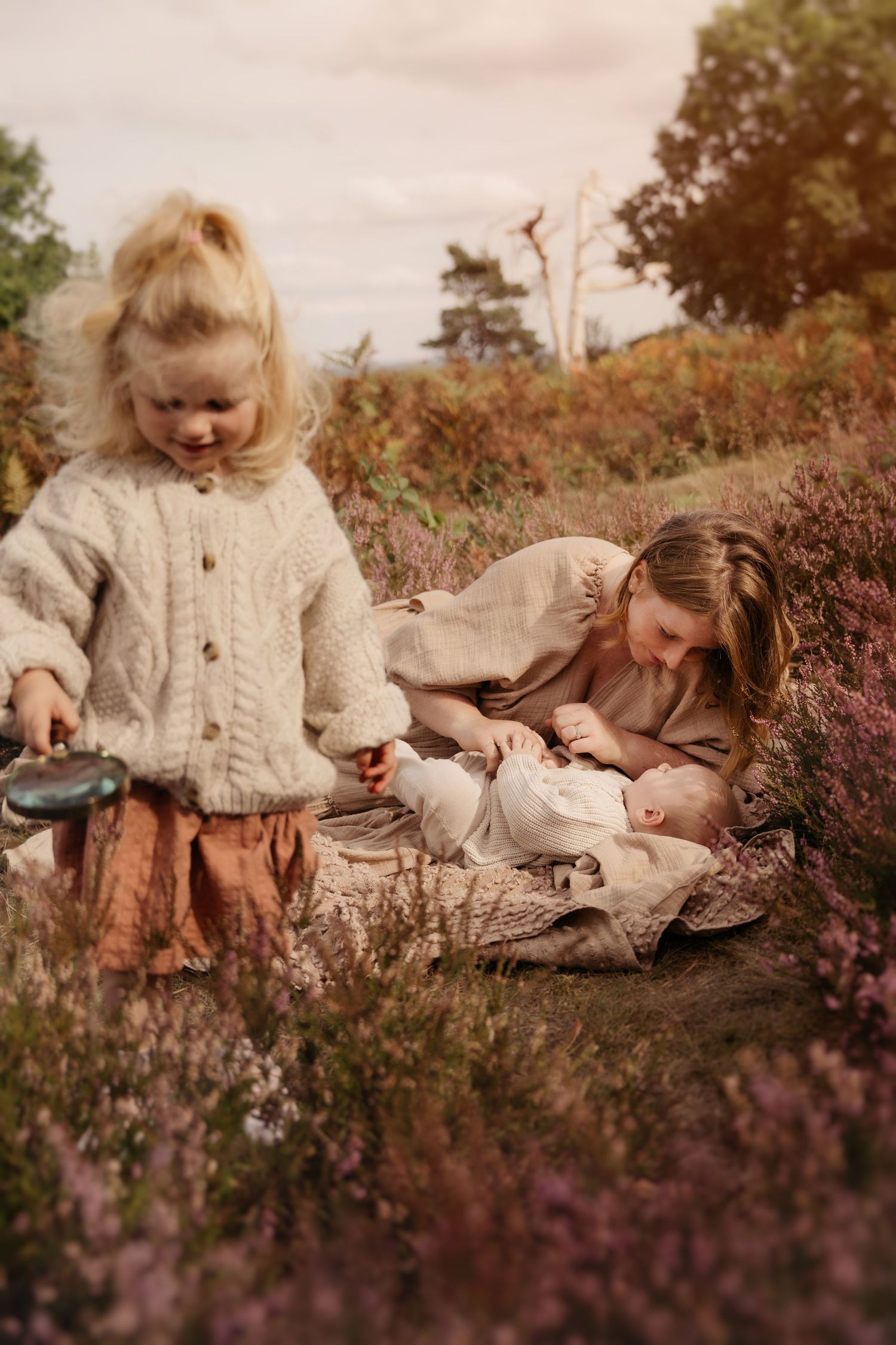 Family plays together in autumn heather fields during a cozy, light-filled family photoshoot in Lickey Hills