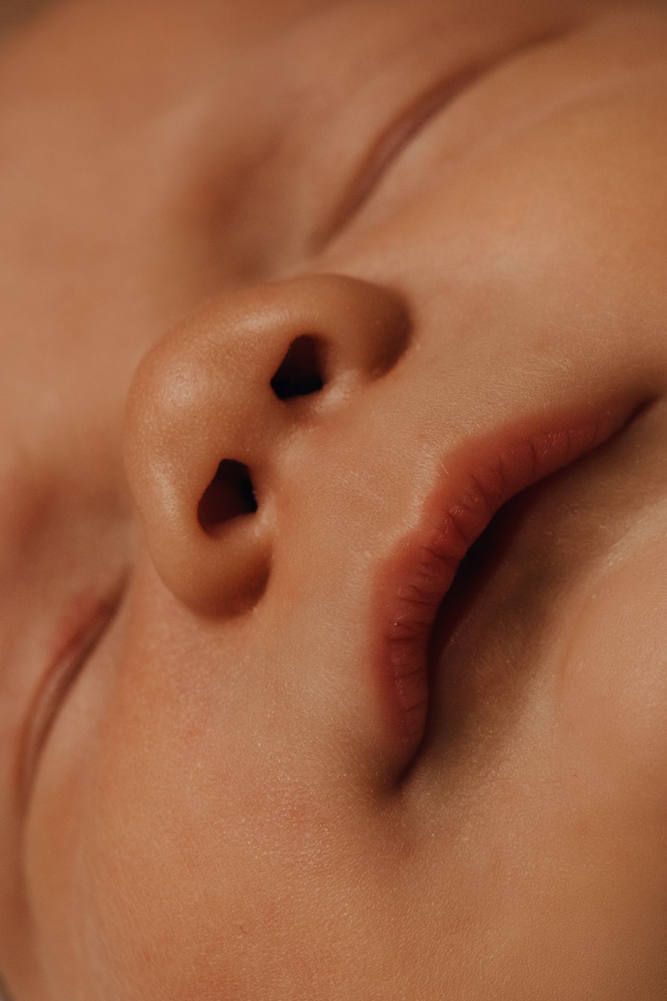 Close-up of a newborn’s lips and nose during a warm natural light lifestyle newborn detail shot.