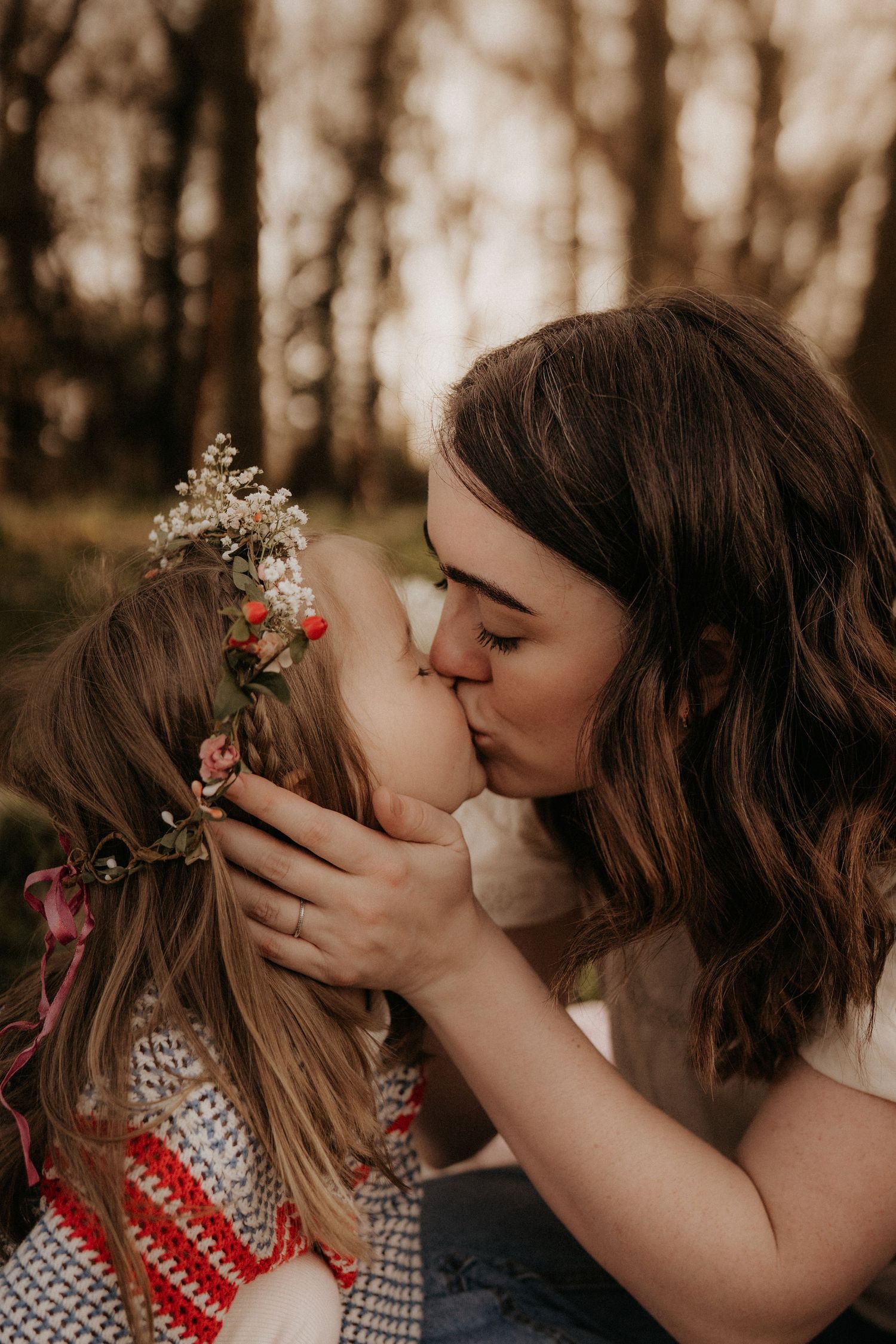 Mother fixing flowers in her child’s hair during a gentle outdoor documentary mother's day photography session in Lichfield