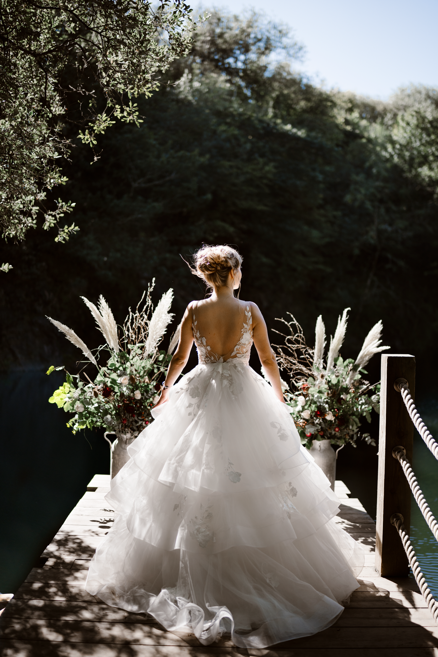 Bride standing outdoors in sunlight, holding her dress during a relaxed wedding portrait, by Soft Stories by Angela