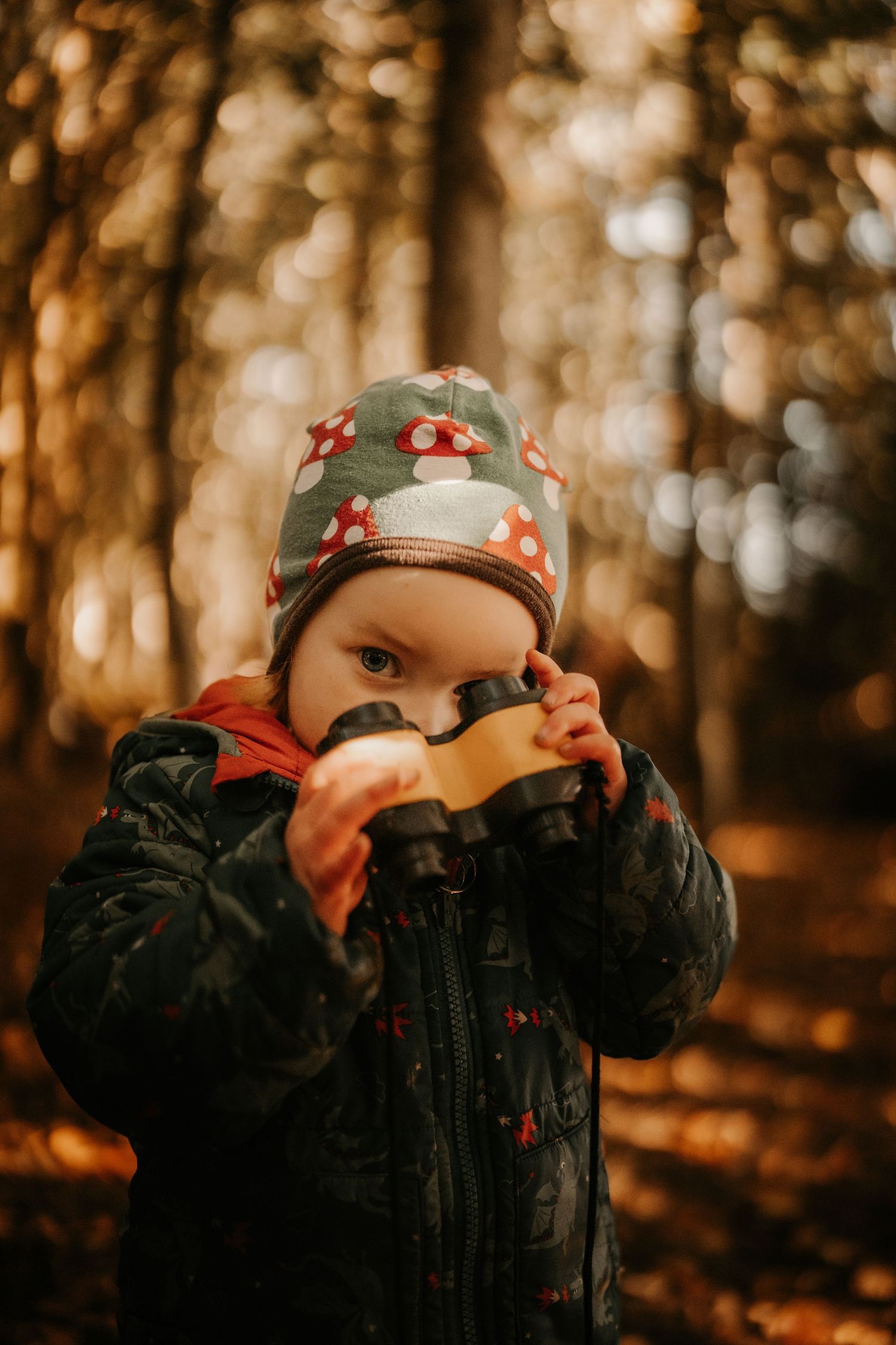 Toddler holding a cup in the woods during a cozy outdoor documentary childhood photoshoot at Little Wildlings Natureplay