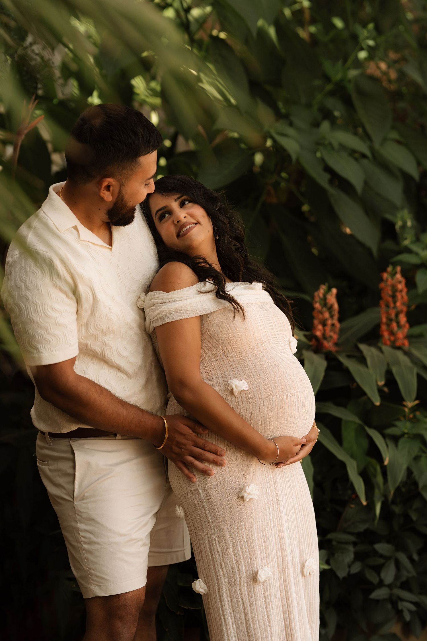 Expecting couple embracing outdoors during a relaxed documentary maternity photoshoot.