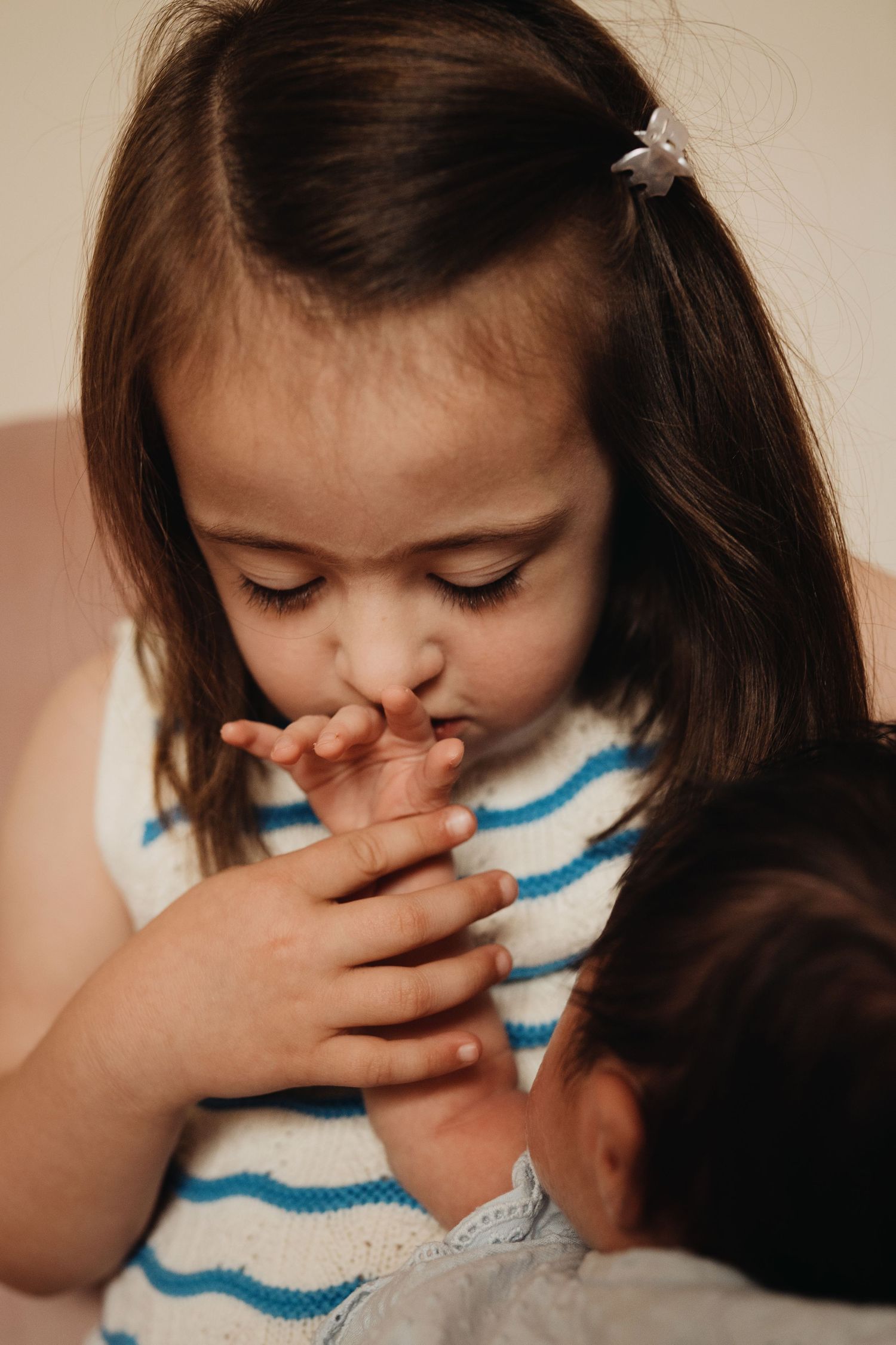 Older sibling gently meeting the newborn during an in-home lifestyle family and newborn photography session.