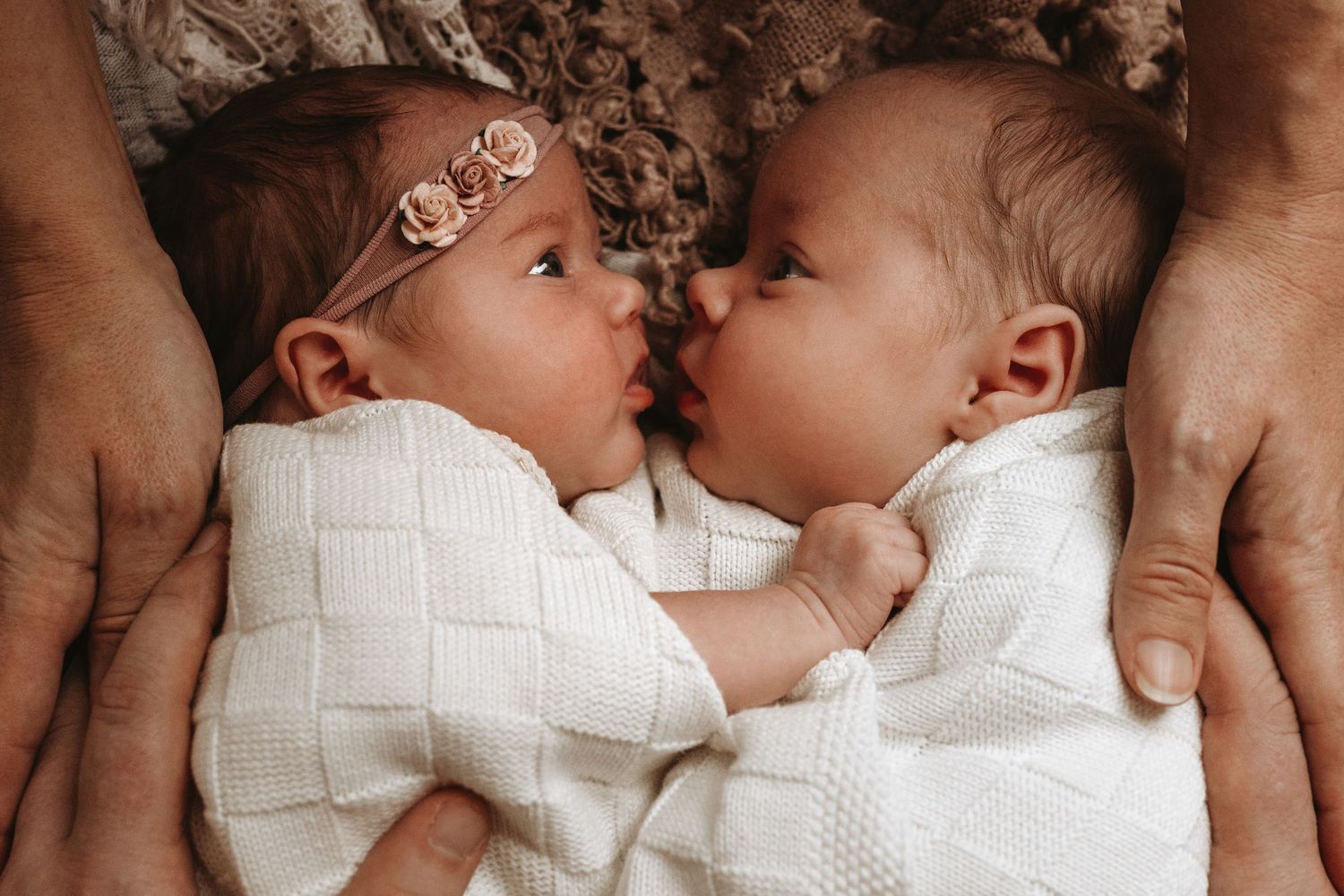 Newborn twins lying together wrapped in blankets during an in-home lifestyle newborn photography session.
