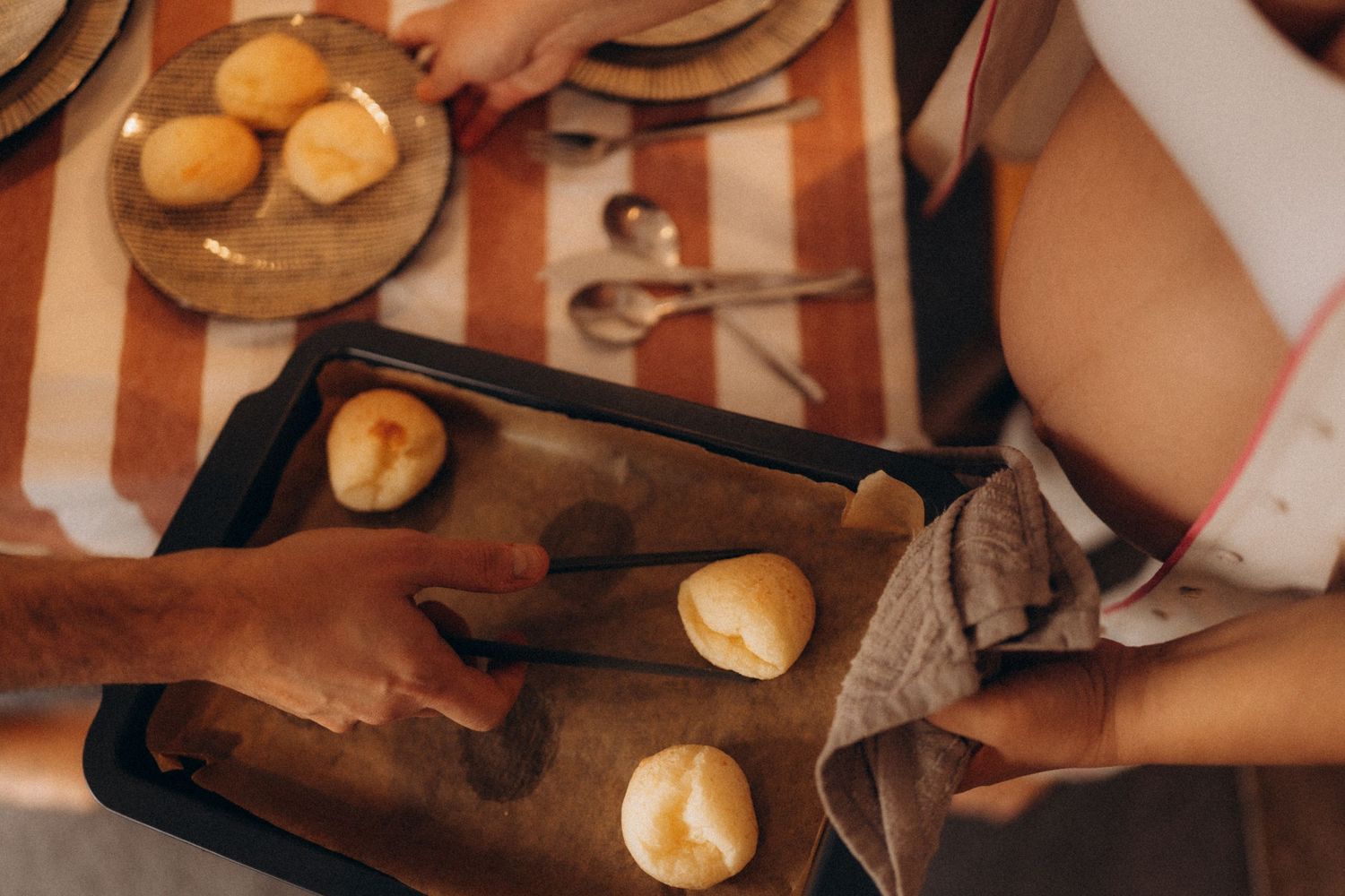 Pregnant parent baking at home during a warm natural light storytelling maternity photography session.