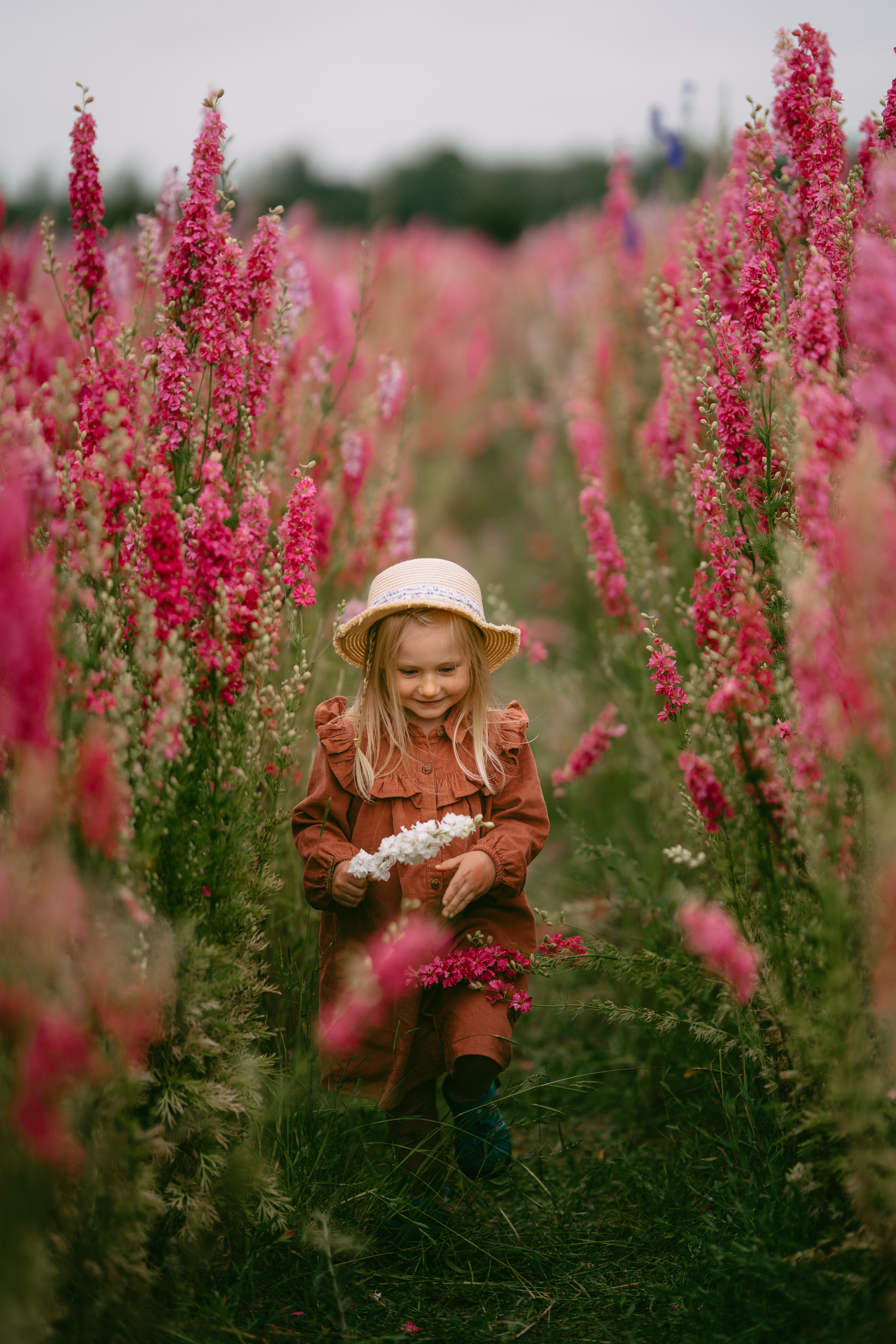 a girl running through delphinium field during a photoshoot