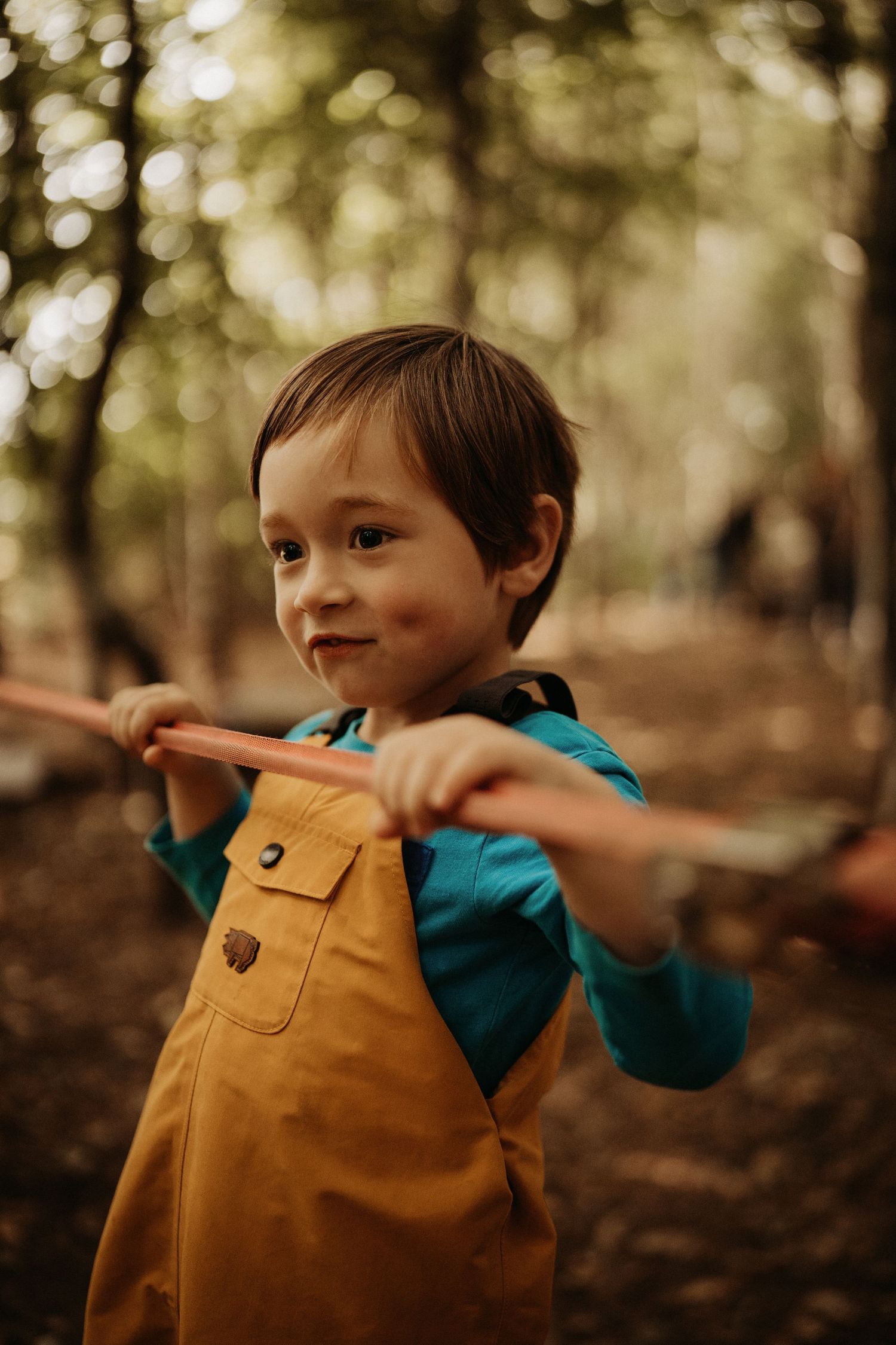 Child playing in the woods during a candid outdoor documentary family photography session for Little Wildlings Natureplay