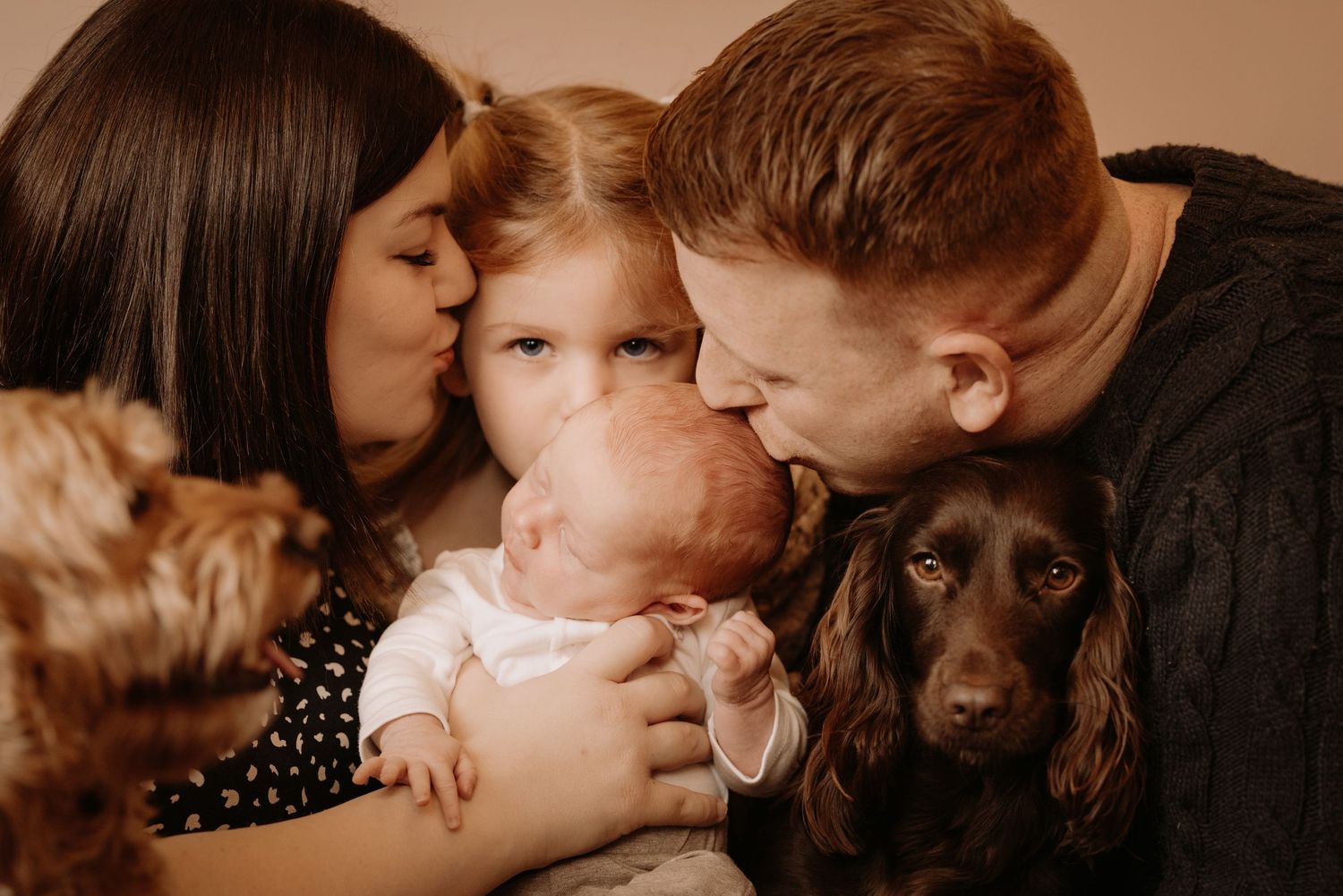 Family cuddling with their newborn and dog during a warm lifestyle newborn photoshoot at home in Wodville
