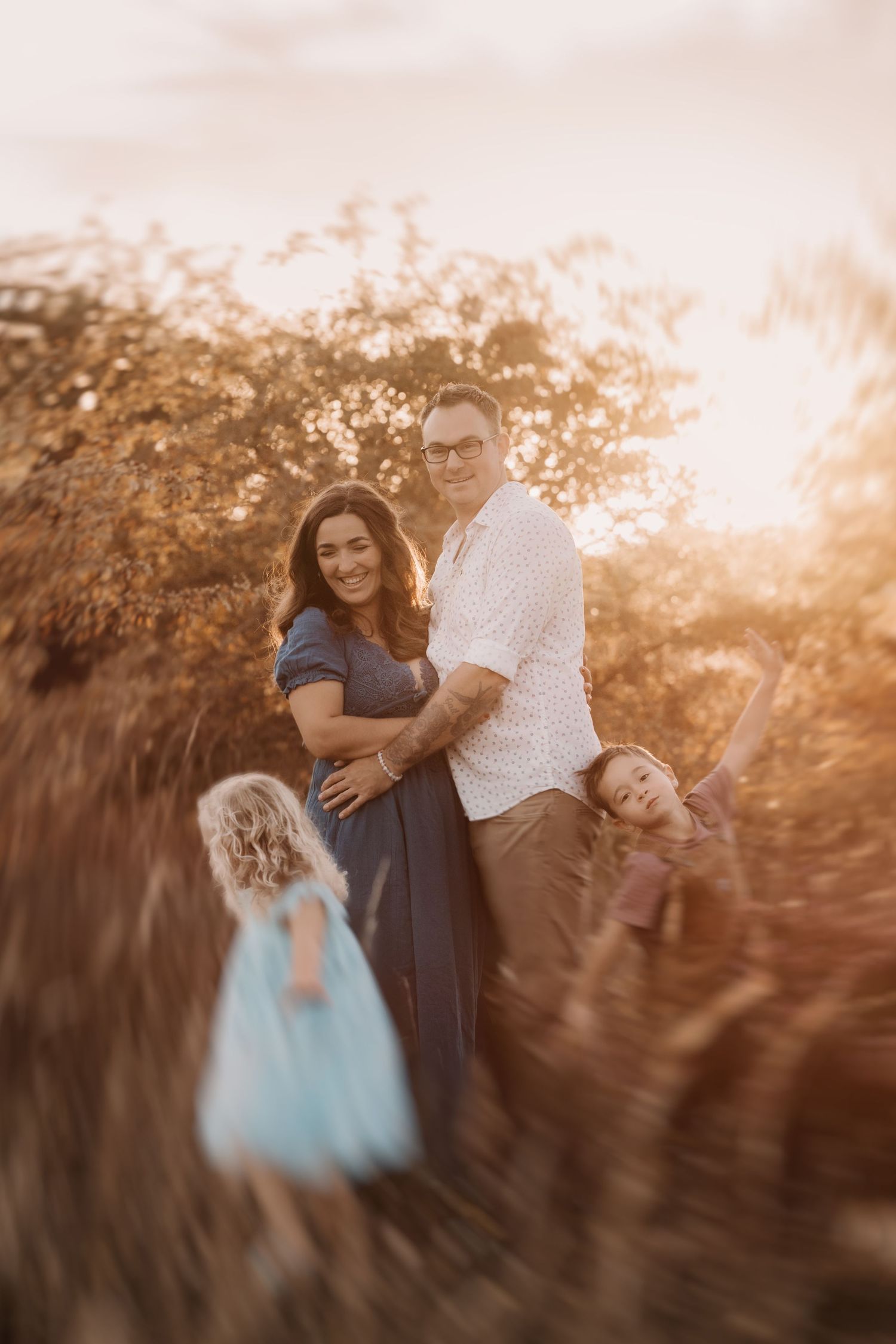 Sister and brother running around their parents during golden hour photoshoot