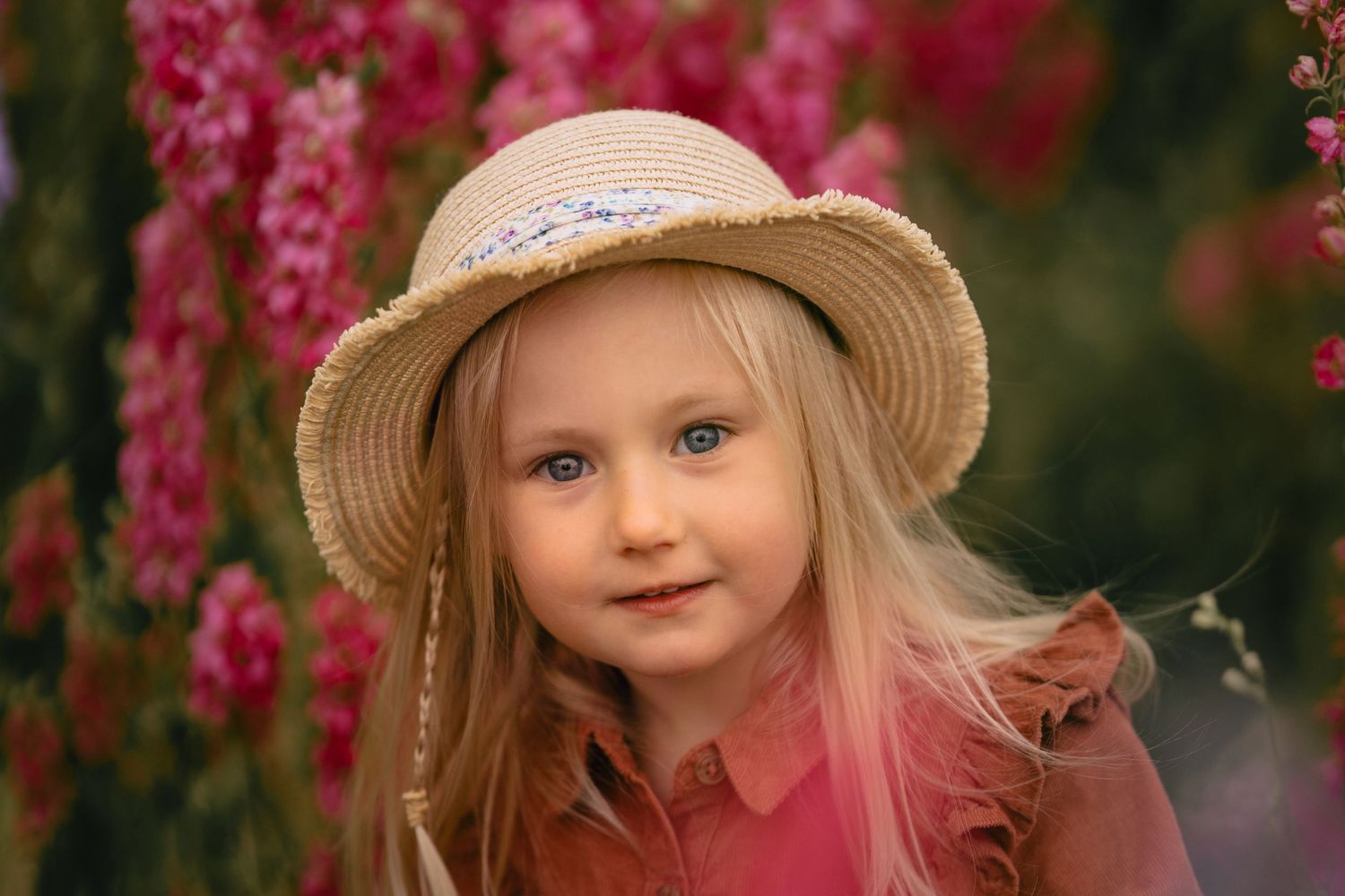 little girl smiling in delphiniums during confetti field mini session