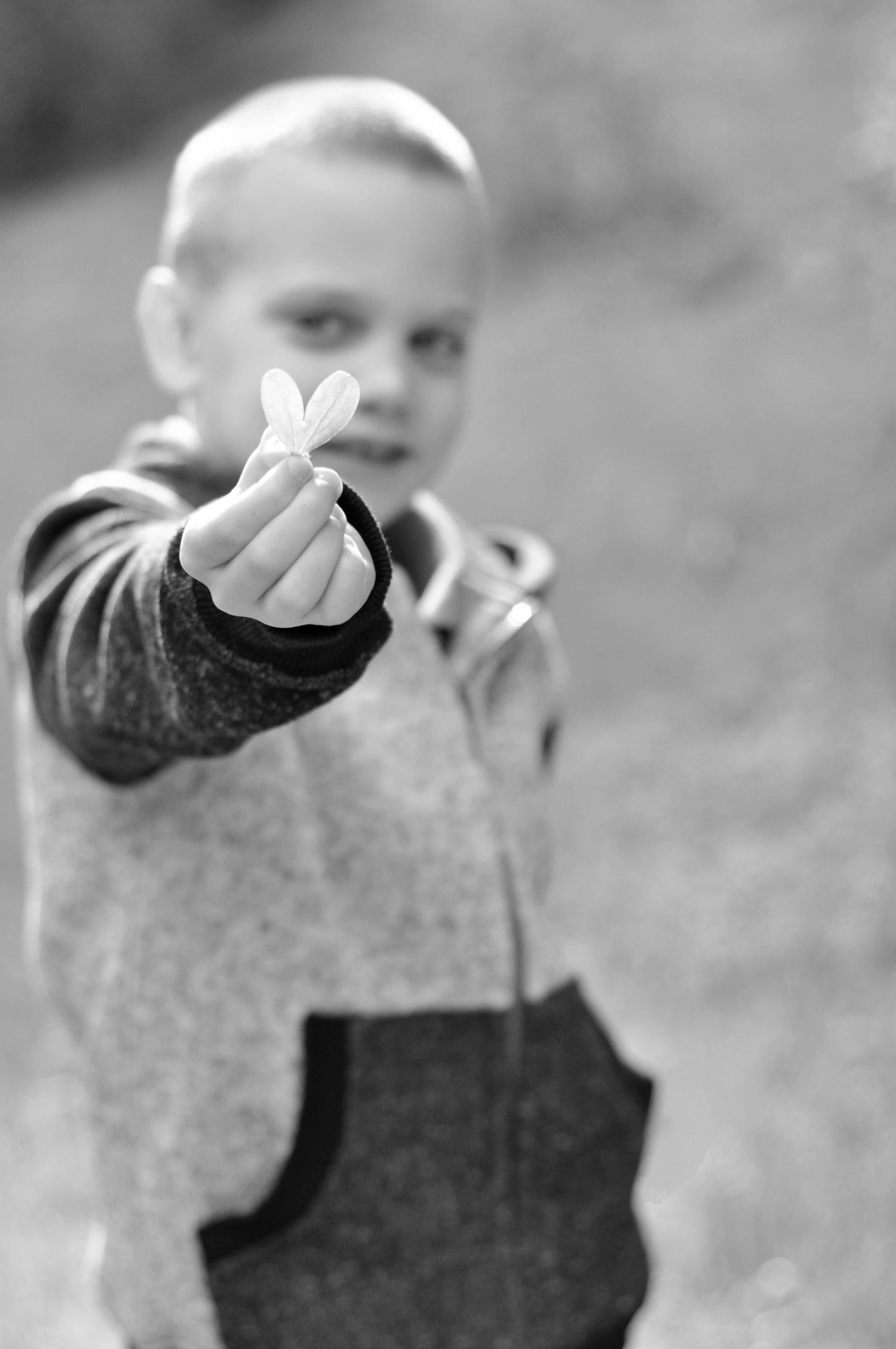 Black and White Children's portrait of a young boy holding a heart shaped leaf