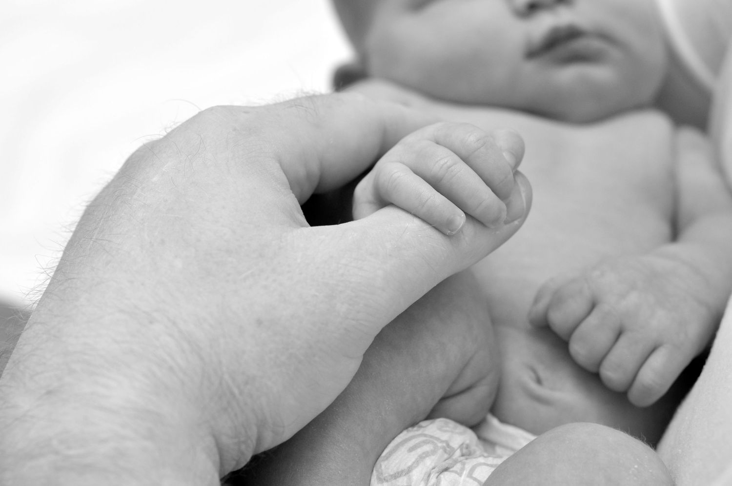 Photography Black and white portrait of dad holding newborn's hand