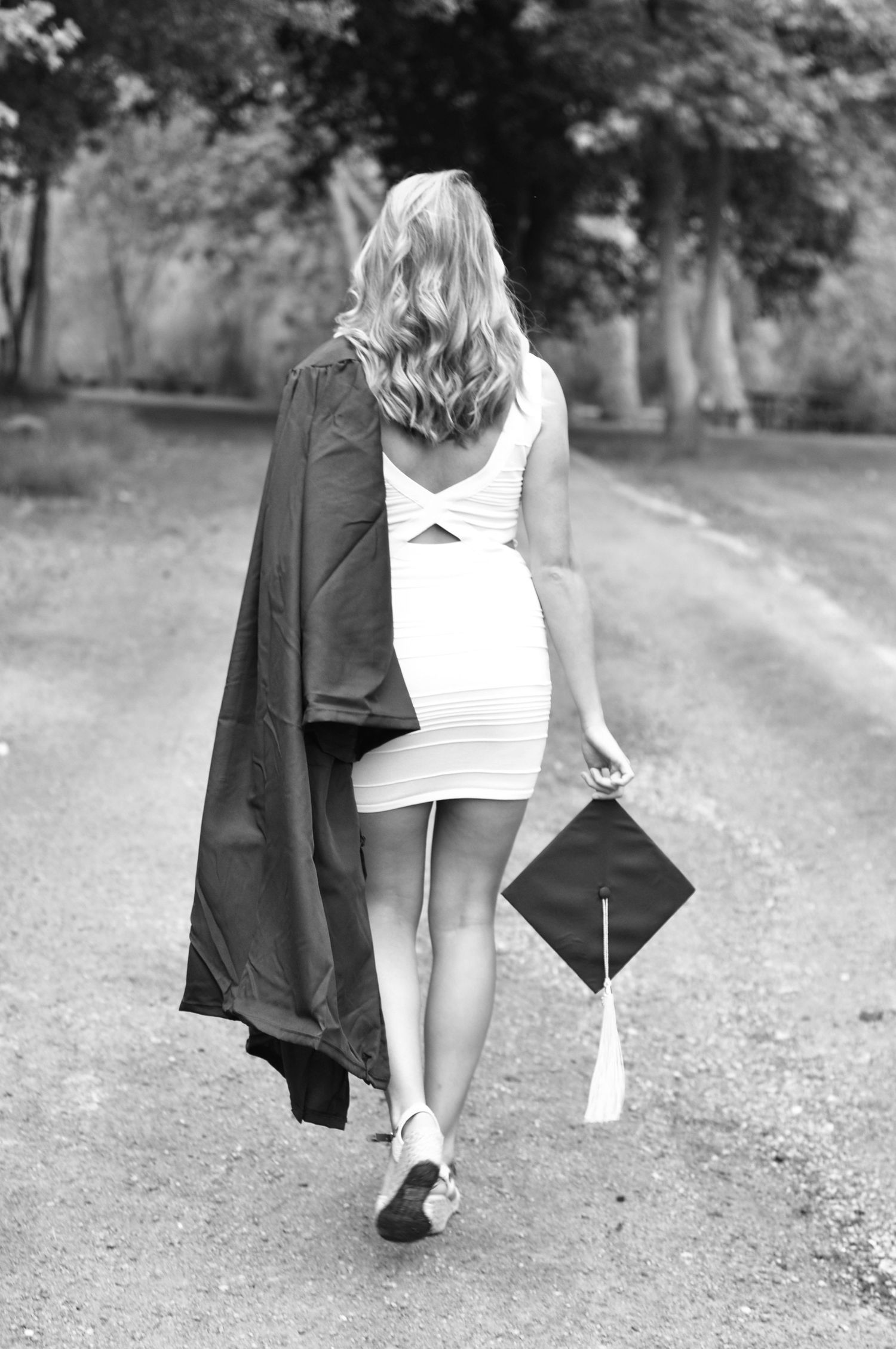 College Graduation portrait with cap and gown in black and white set outdoors