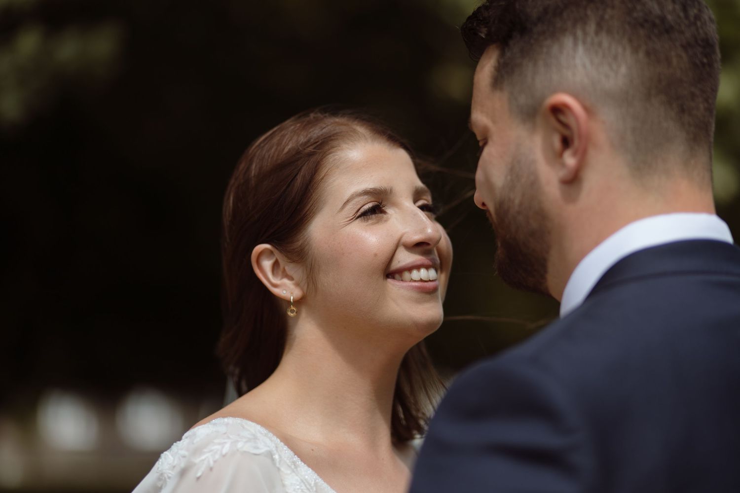 Bride looking at her husband smiling during couple portraits on their wedding day at Hensol Castle in Pontyclun.