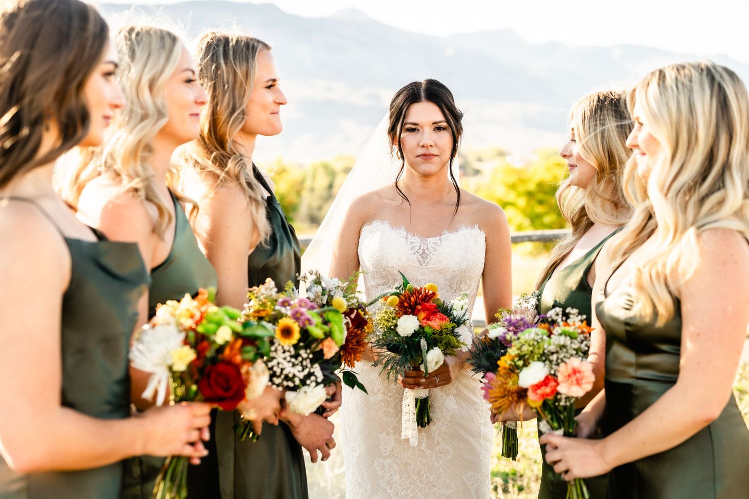 Bridesmaids and bride with green gowns and wildflowers by Utah Wedding Photographer