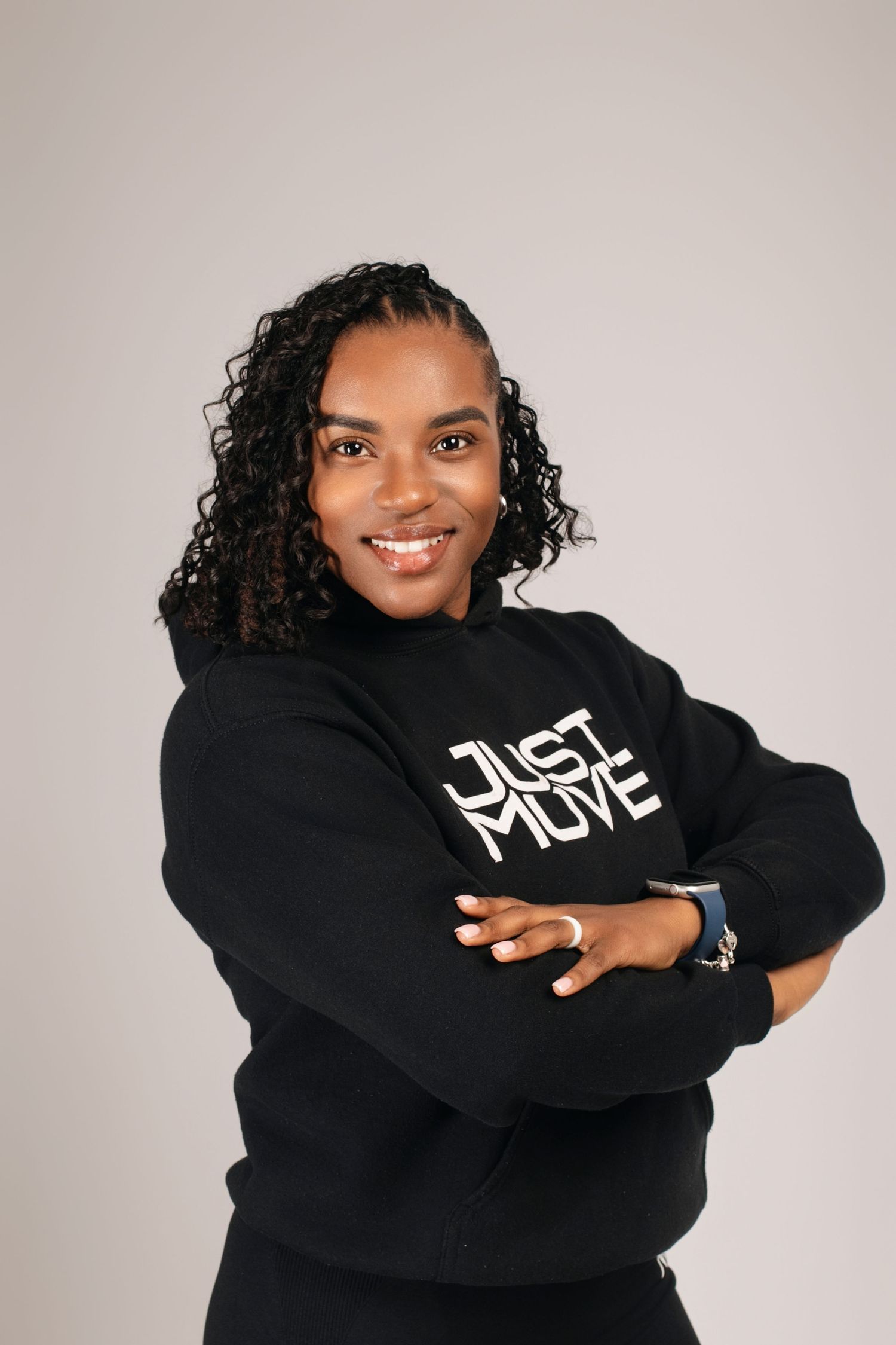Woman in black 'Just Move' sweatshirt showing various expressions in studio photoshoot.