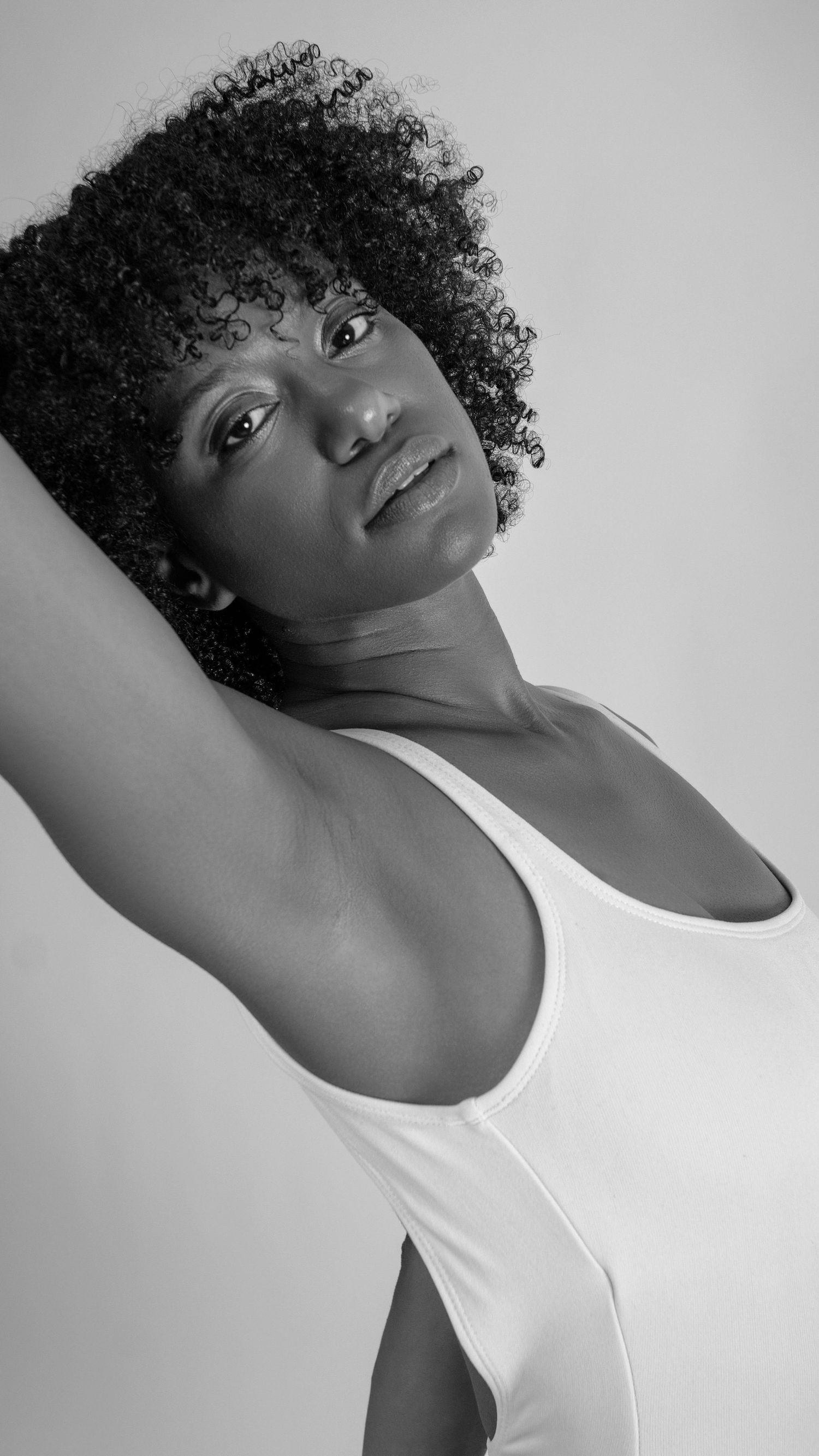 Black and white artistic portraits showing elegant poses in sleeveless white top.