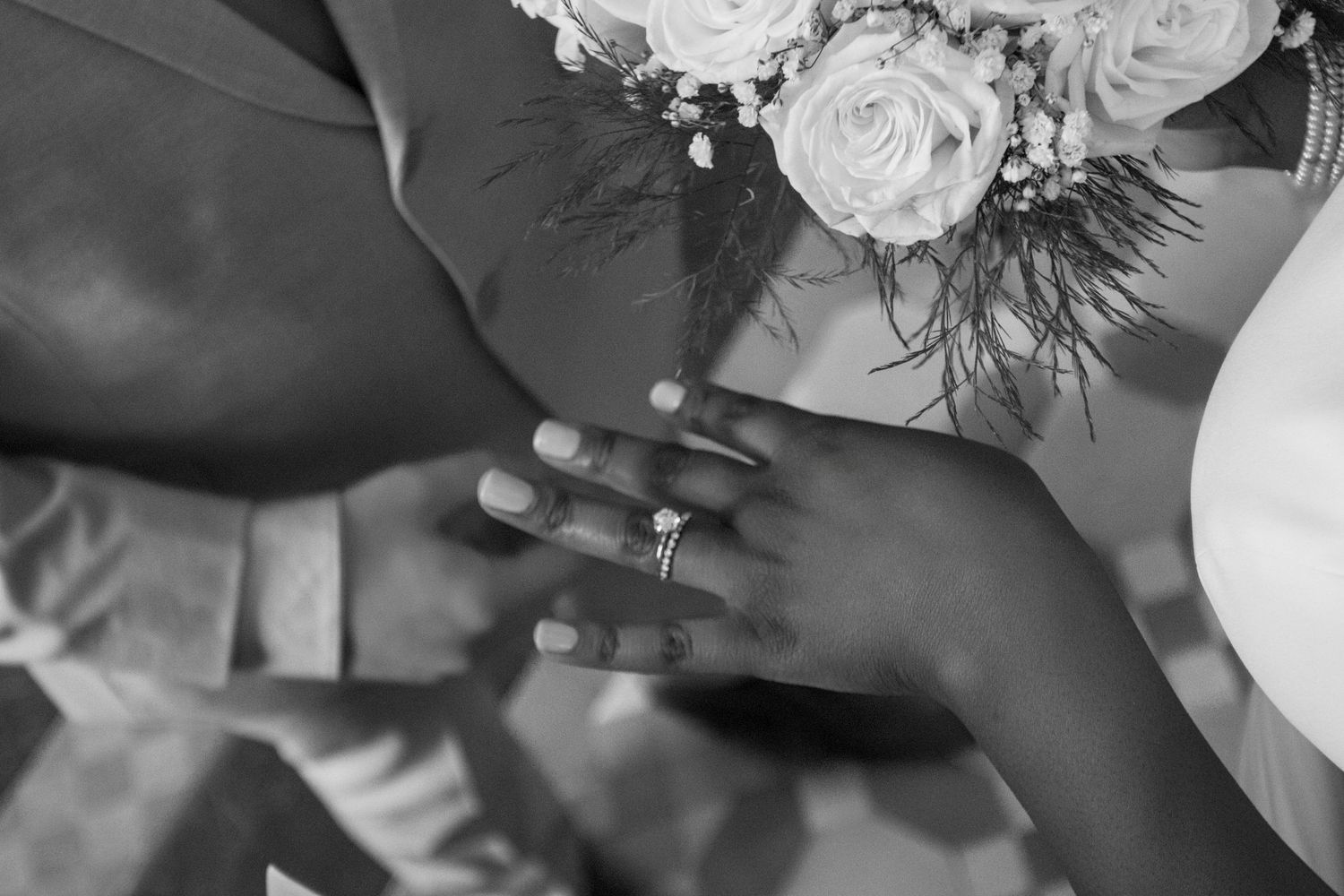 A collection of black and white wedding photos showing floral arrangements and hands.