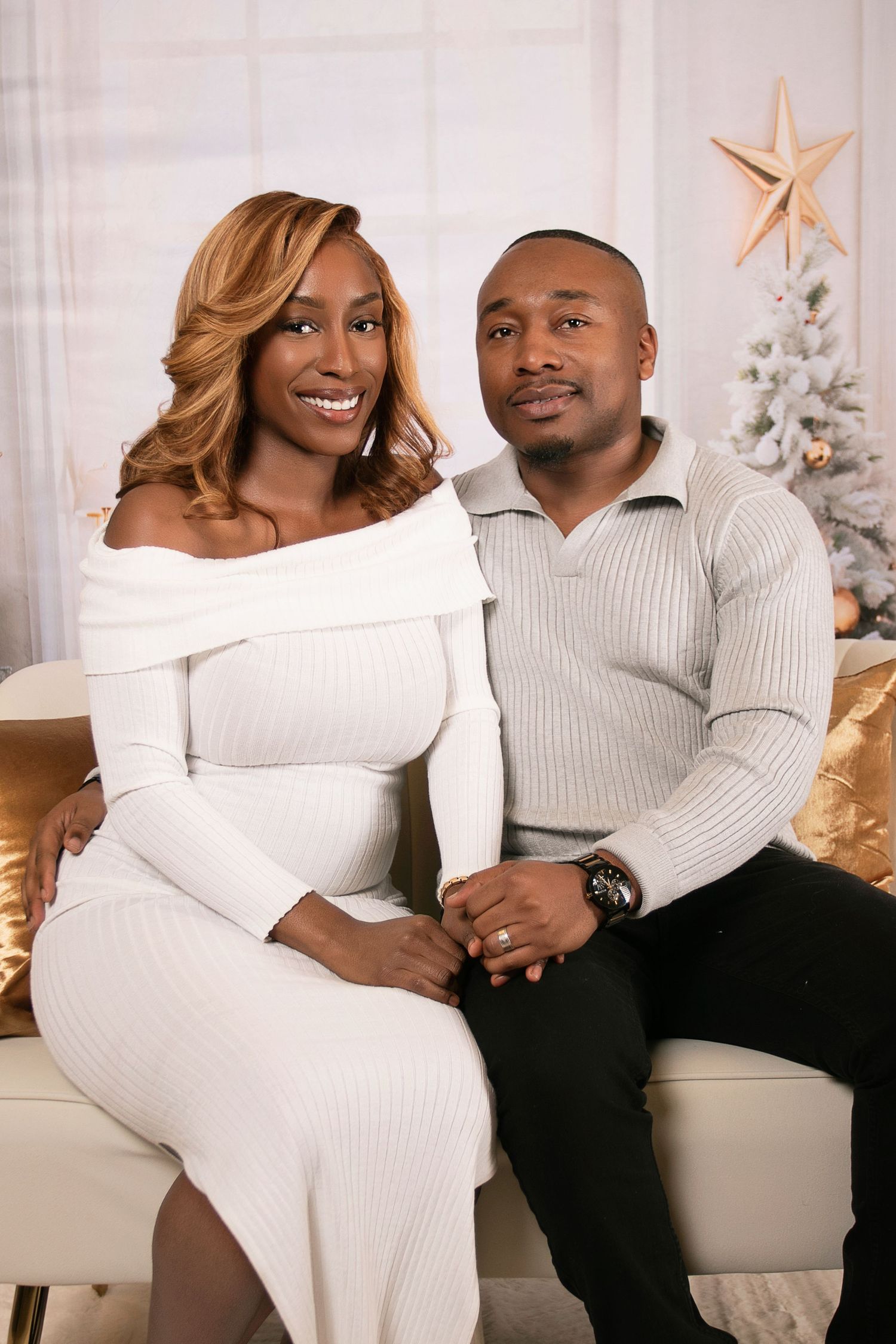 Cozy holiday couples photoshoot with white sweaters and Christmas decor.