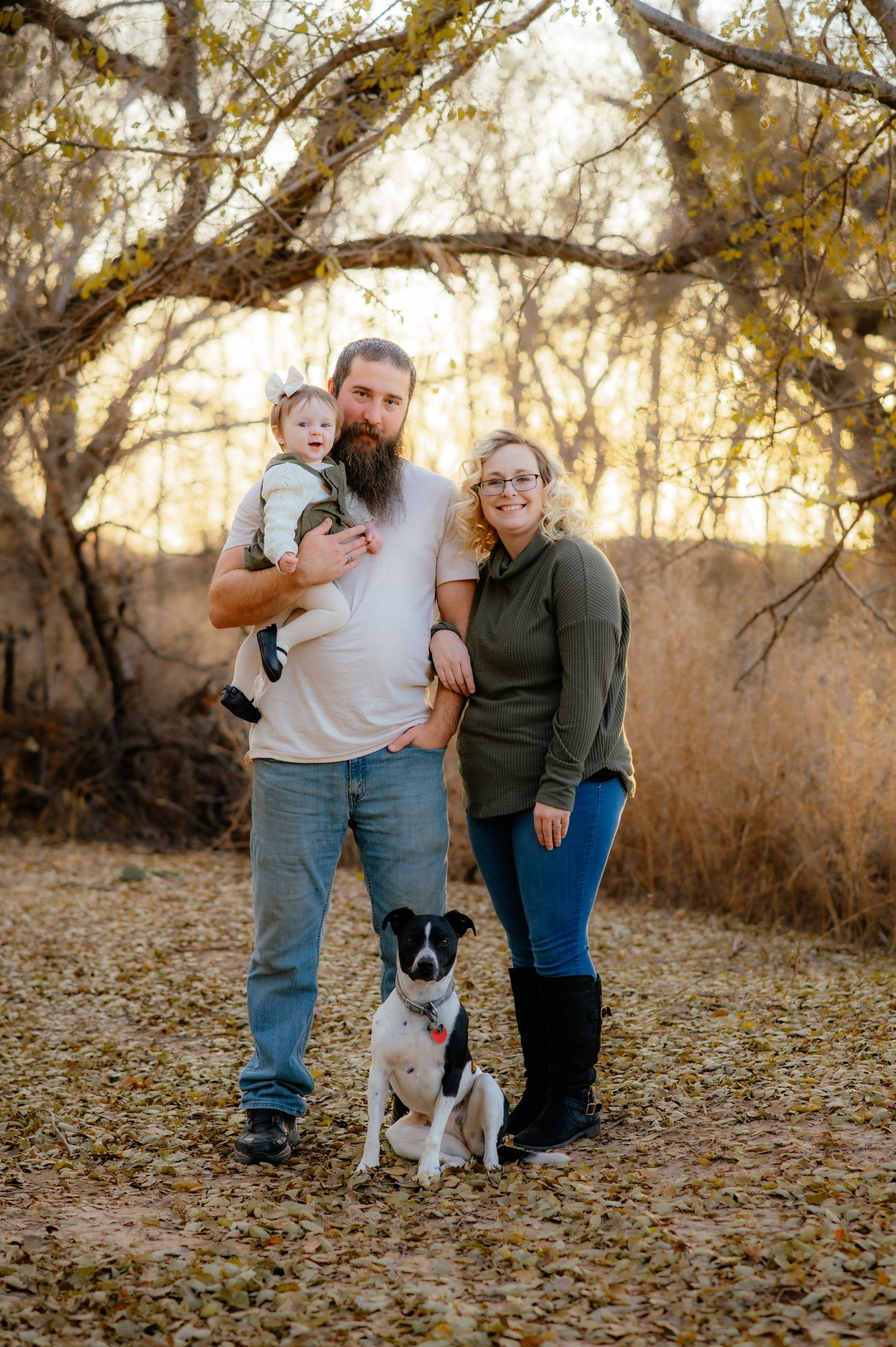 A couple pose for Enid family photos with their little girl and dog.