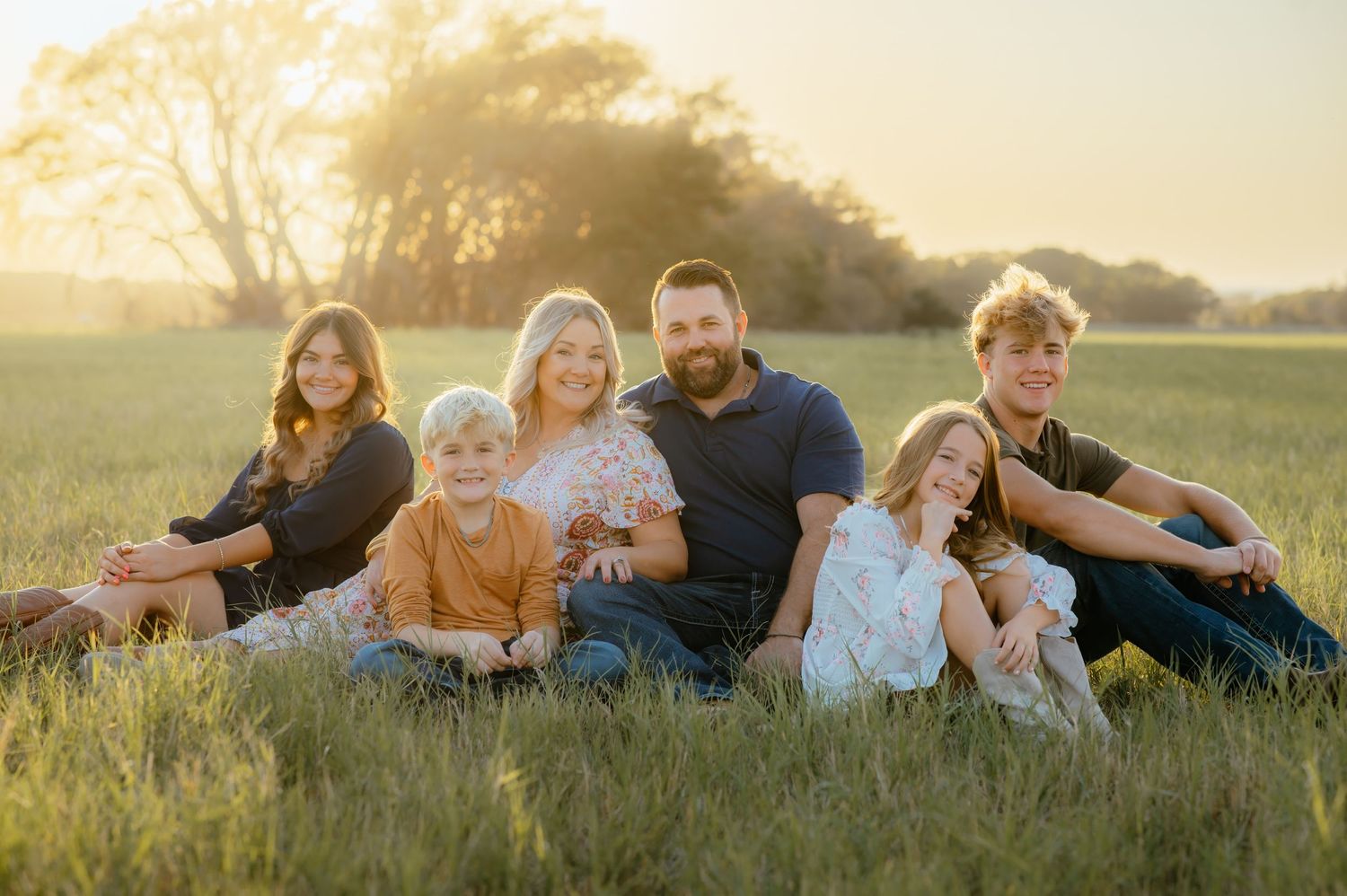 Northwest Oklahoma family posing during golden hour while an Alva Oklahoma photographer takes their family photos.