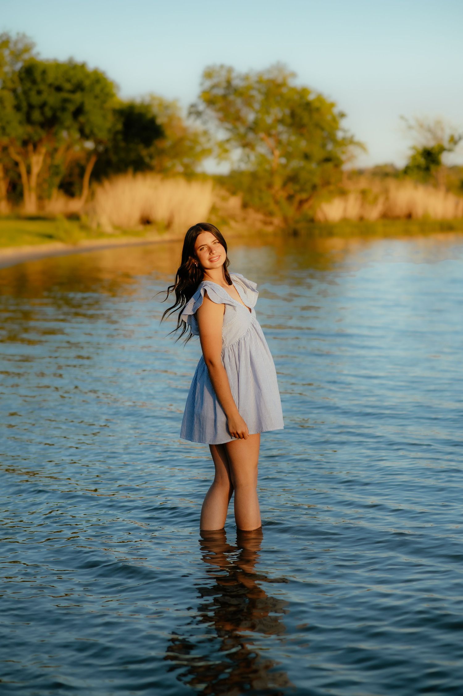 Senior girl standing in water for Enid OK senior photos.