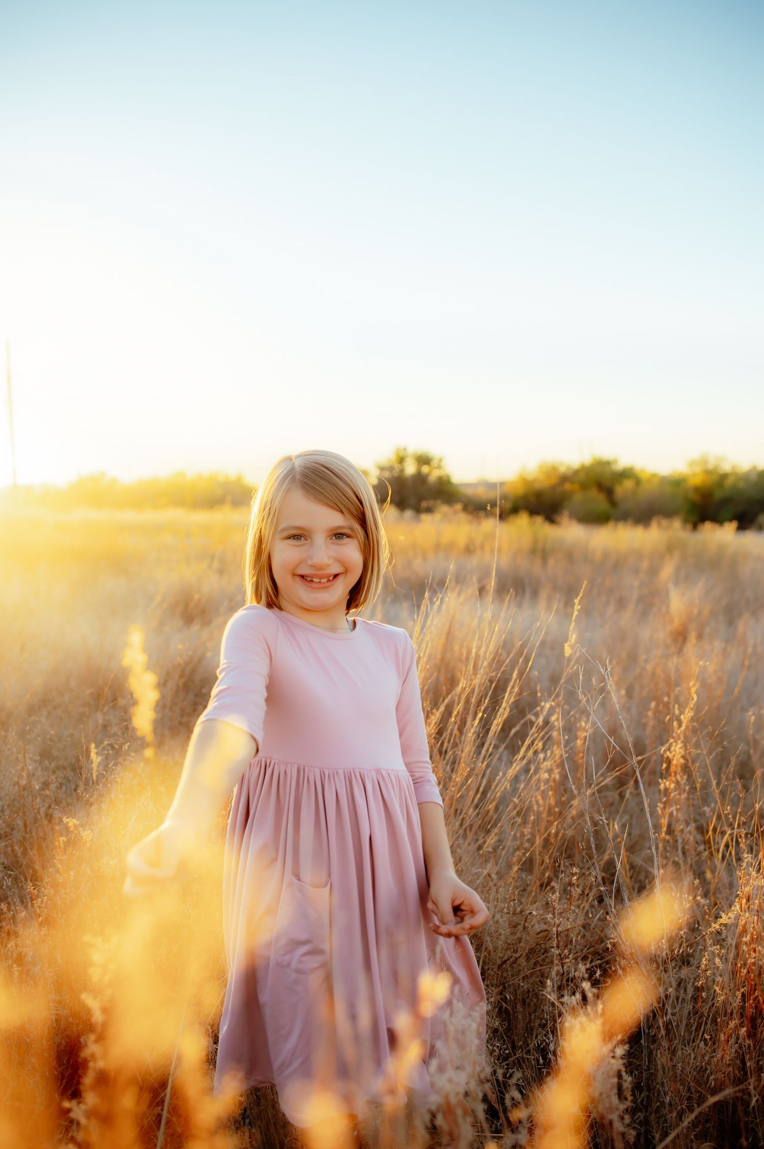Little girl posing in a field of grass for a photo near Enid Oklahoma.