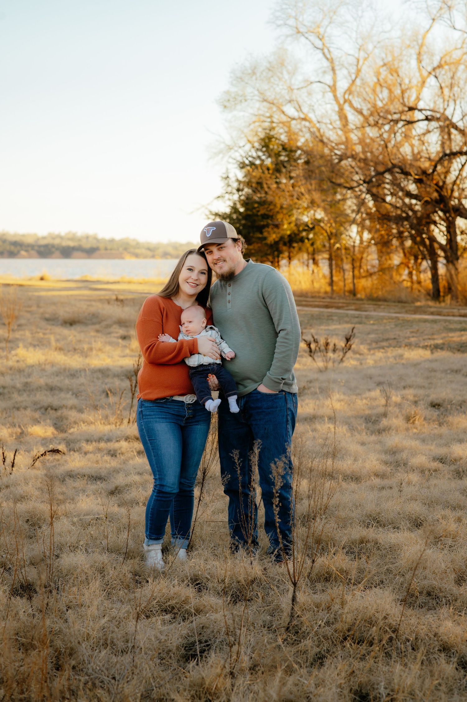 Two parents holding their baby and smiling for a photo near Jet Oklahoma.