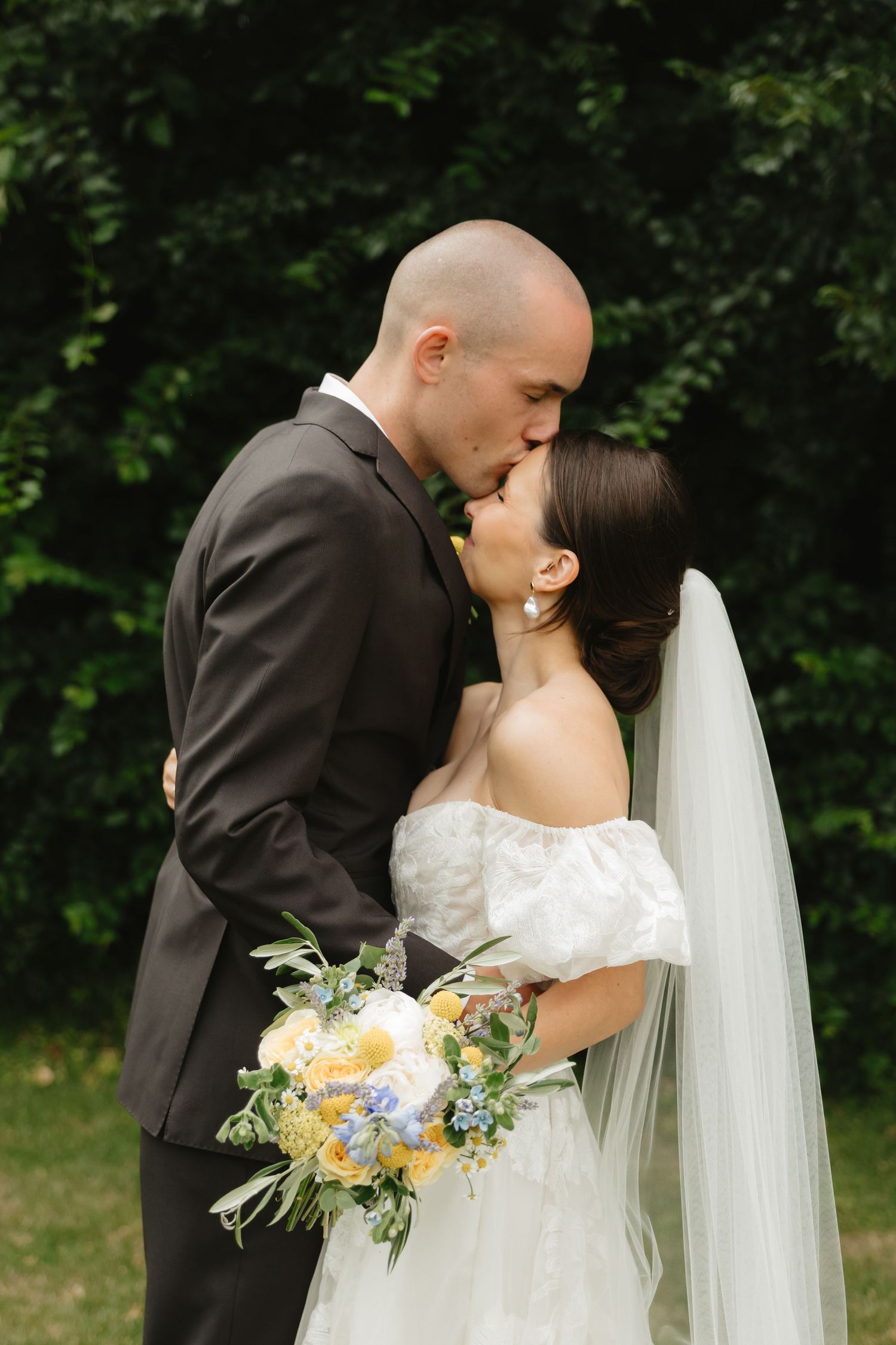 Romantic wedding portrait of couple embracing in a garden setting.