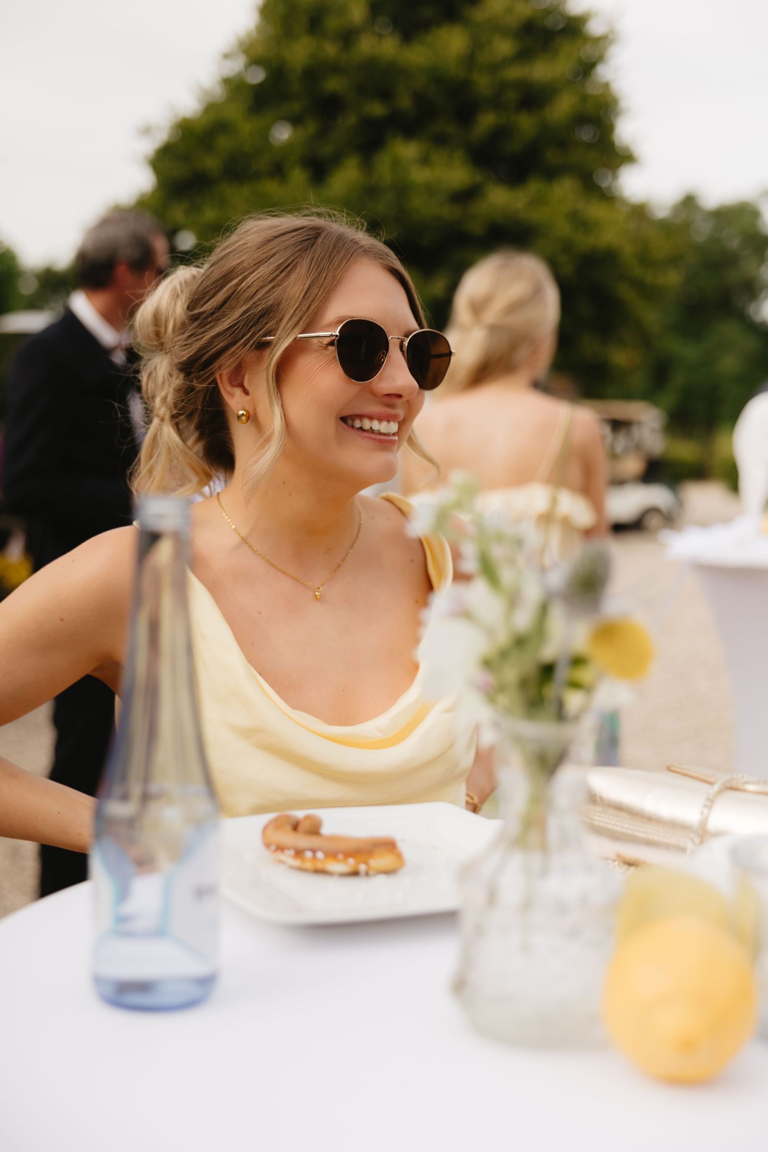Wedding guest enjoying an outdoor reception at a white-clothed table.