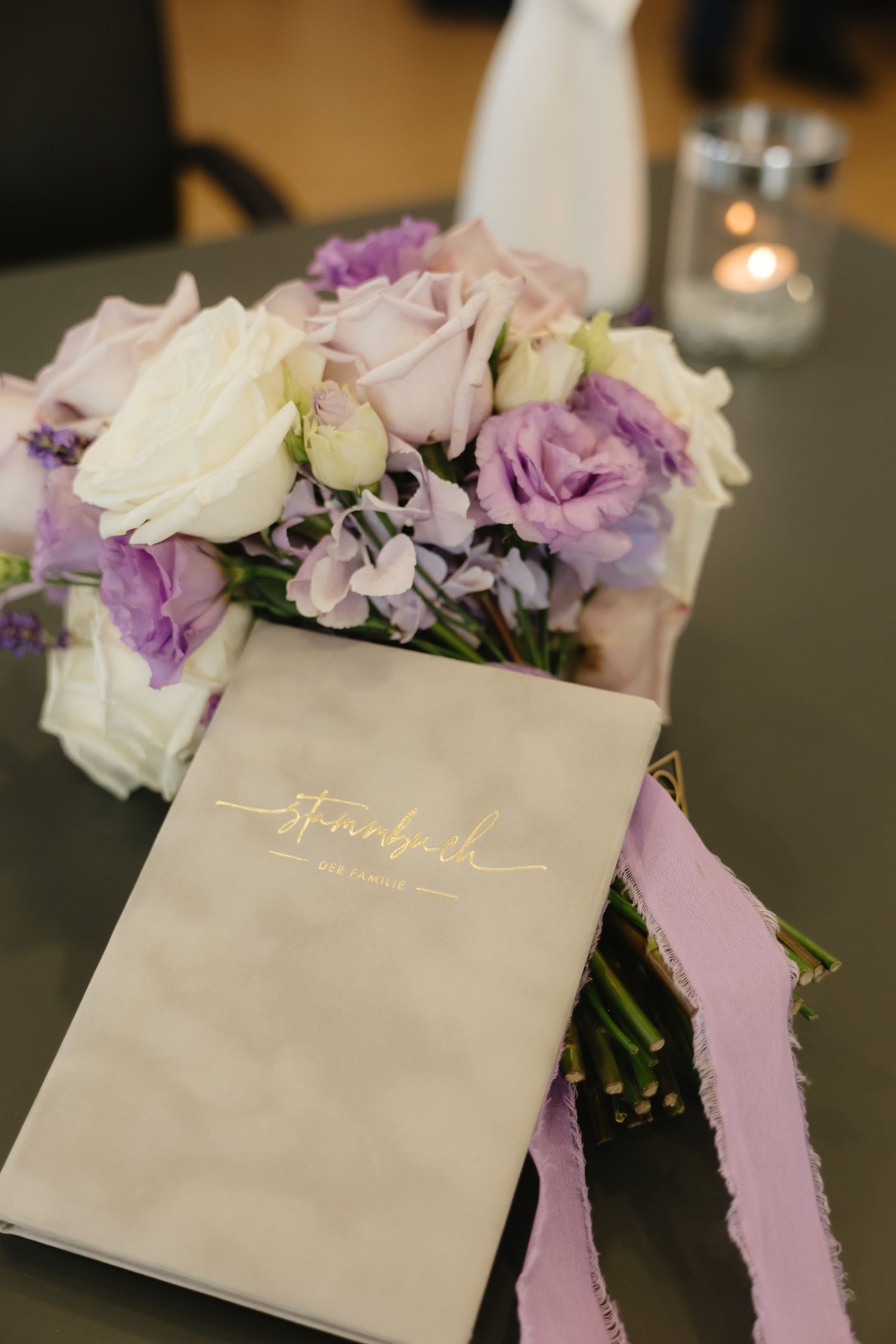 Wedding reception table details with purple and white floral arrangements and elegant name cards.