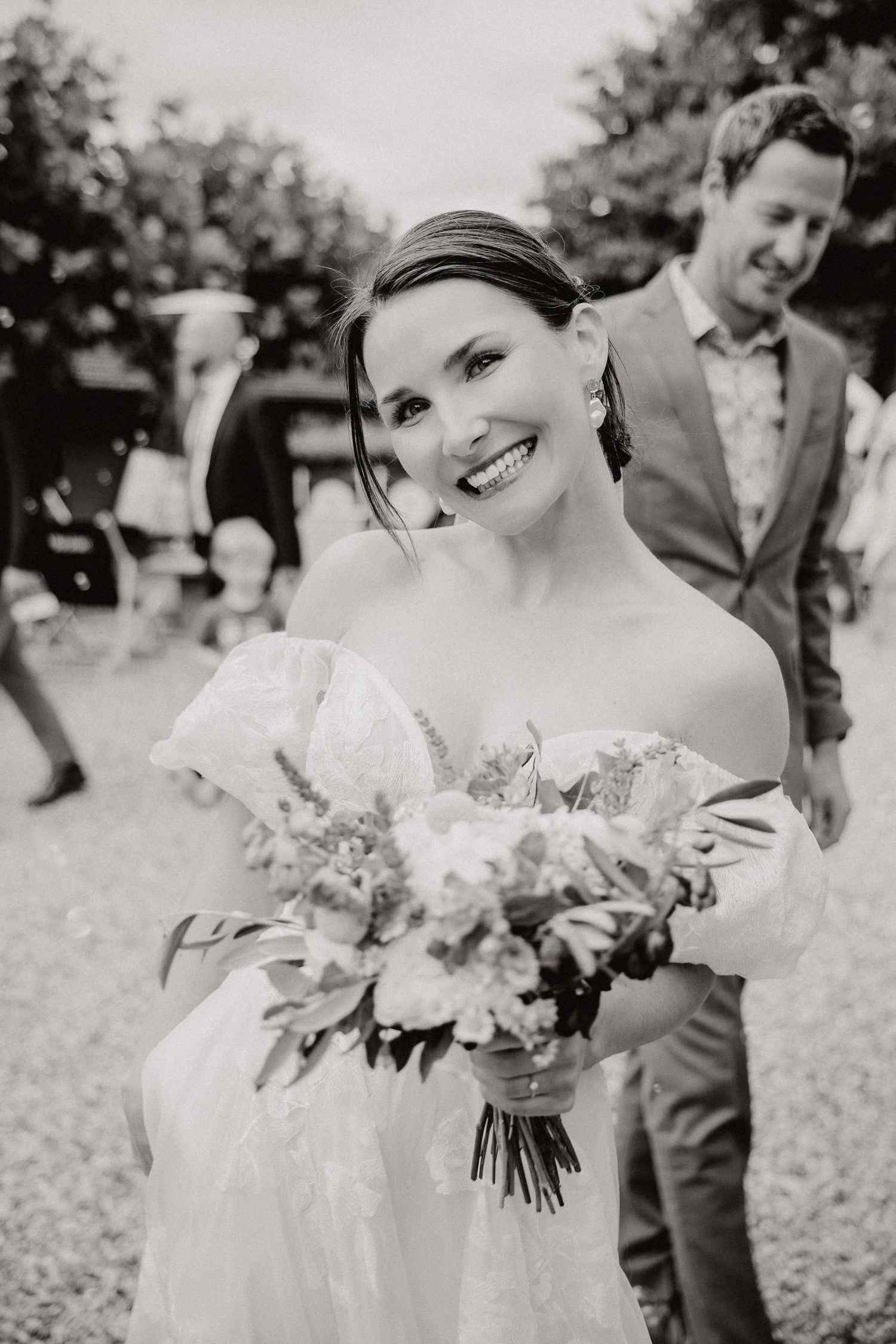 Black and white photo series of a bride holding a beautiful floral bouquet outdoors.