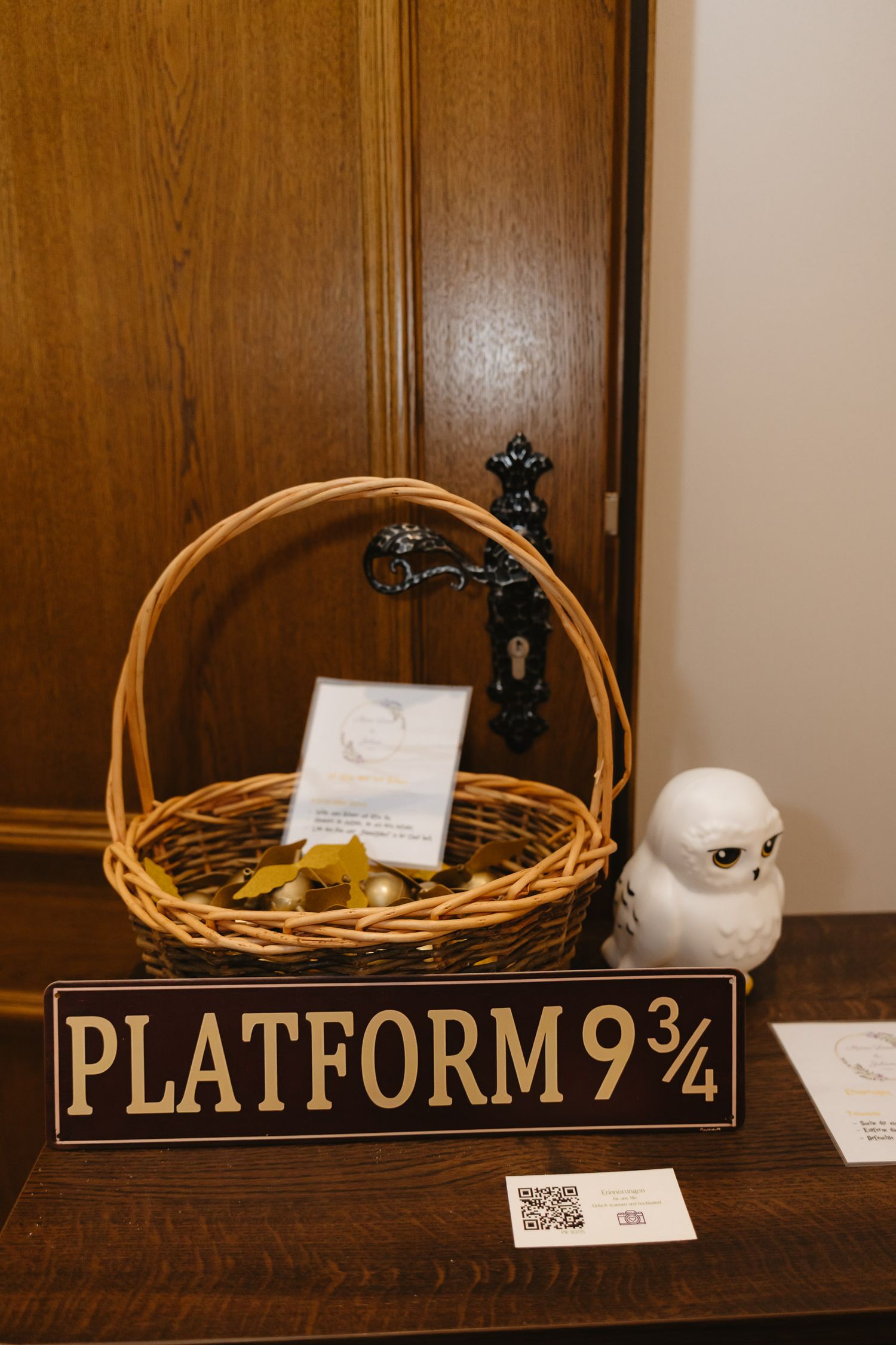 A sequence of wooden signs reading 'Platform 9 3/4' displayed on a brown shelf with decorative wicker baskets.
