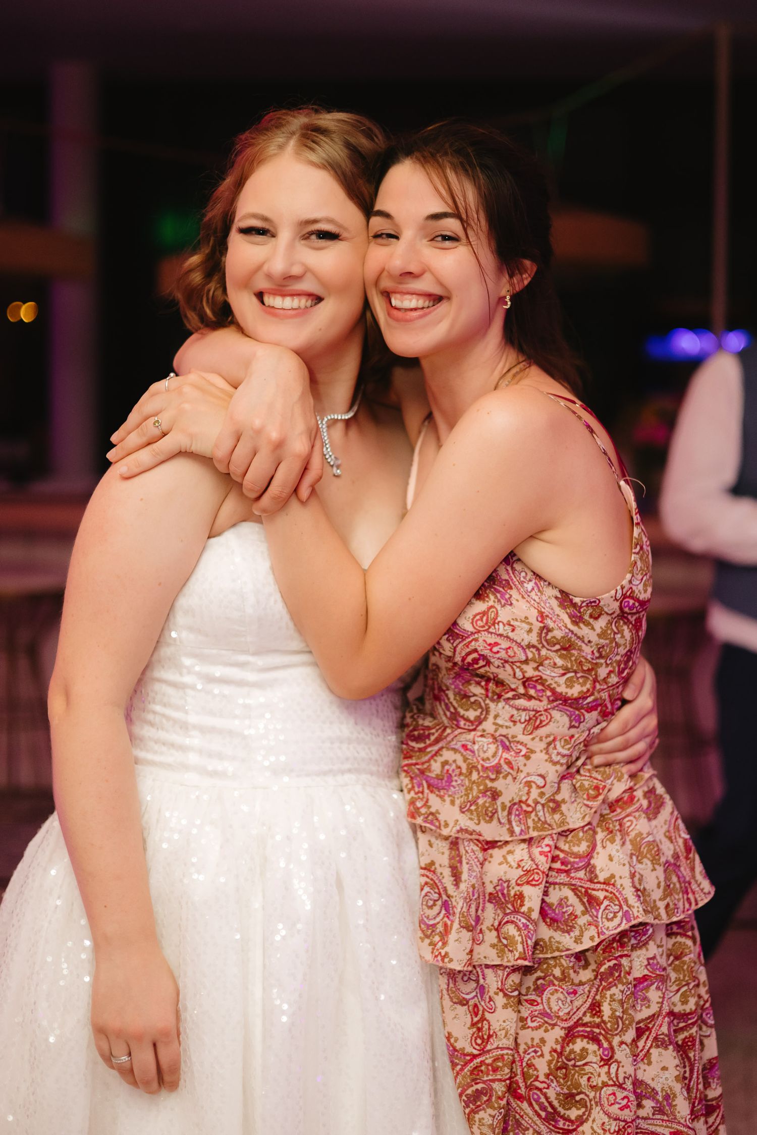 A bride in a white dress embraces someone wearing a floral dress in a series of candid reception photos.
