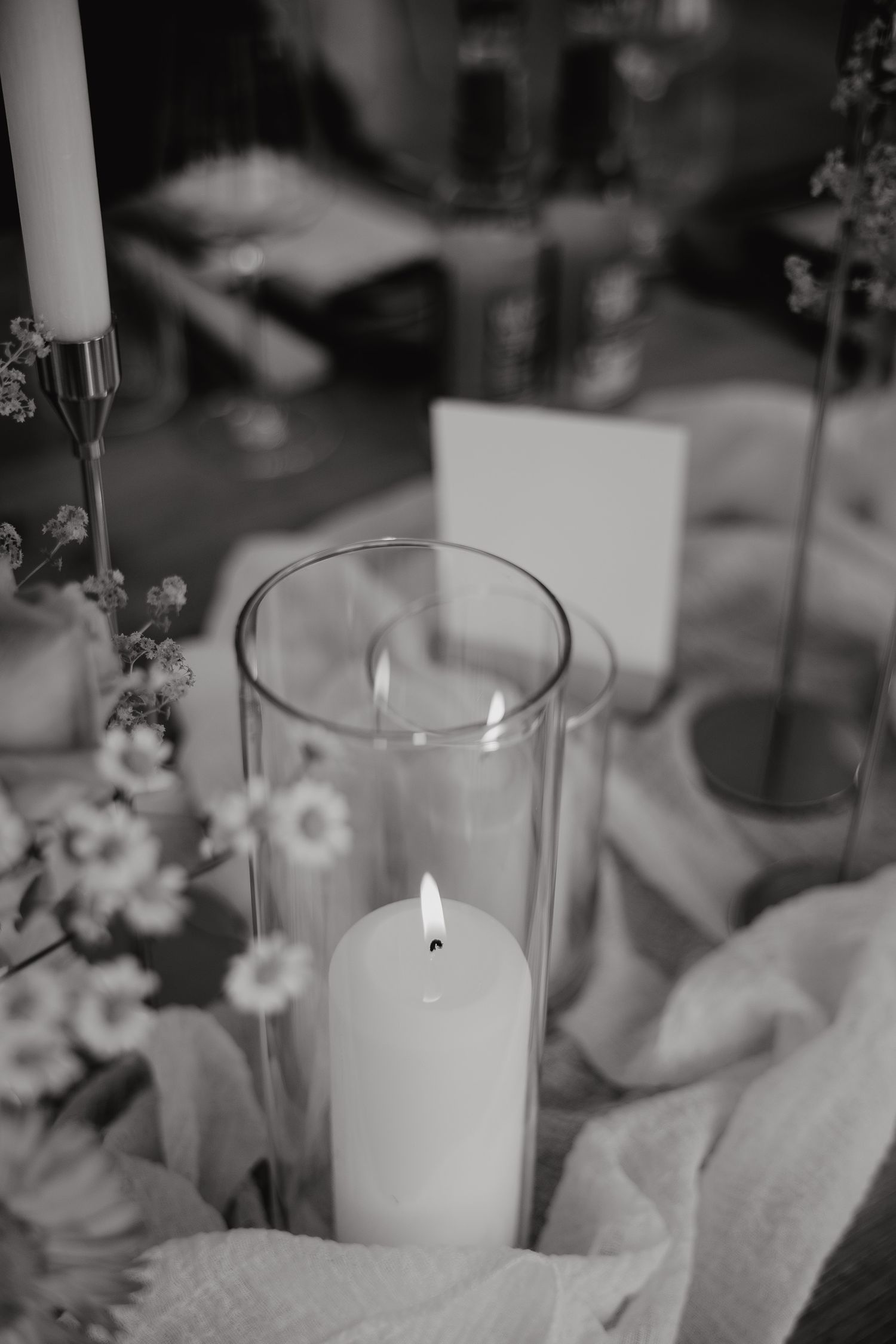 Elegant white candles in glass holders create a romantic ambiance for wedding table decor.