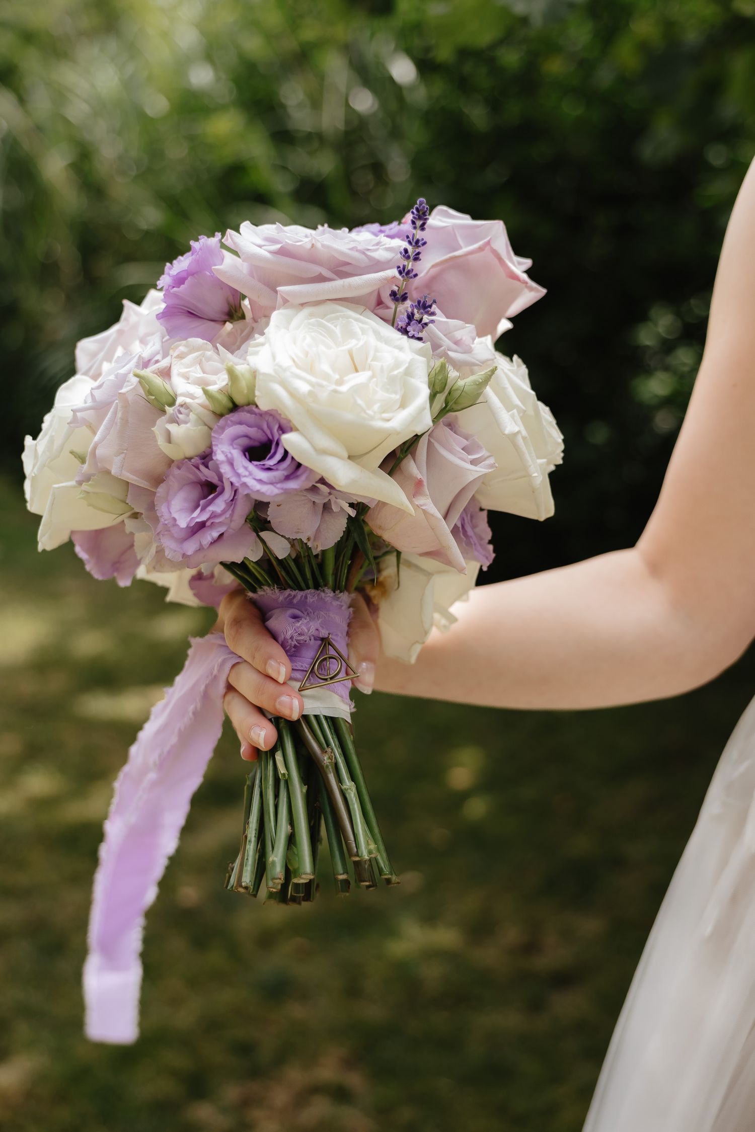 A bridal bouquet featuring white roses and purple flowers tied with a lavender ribbon shown from three different angles.