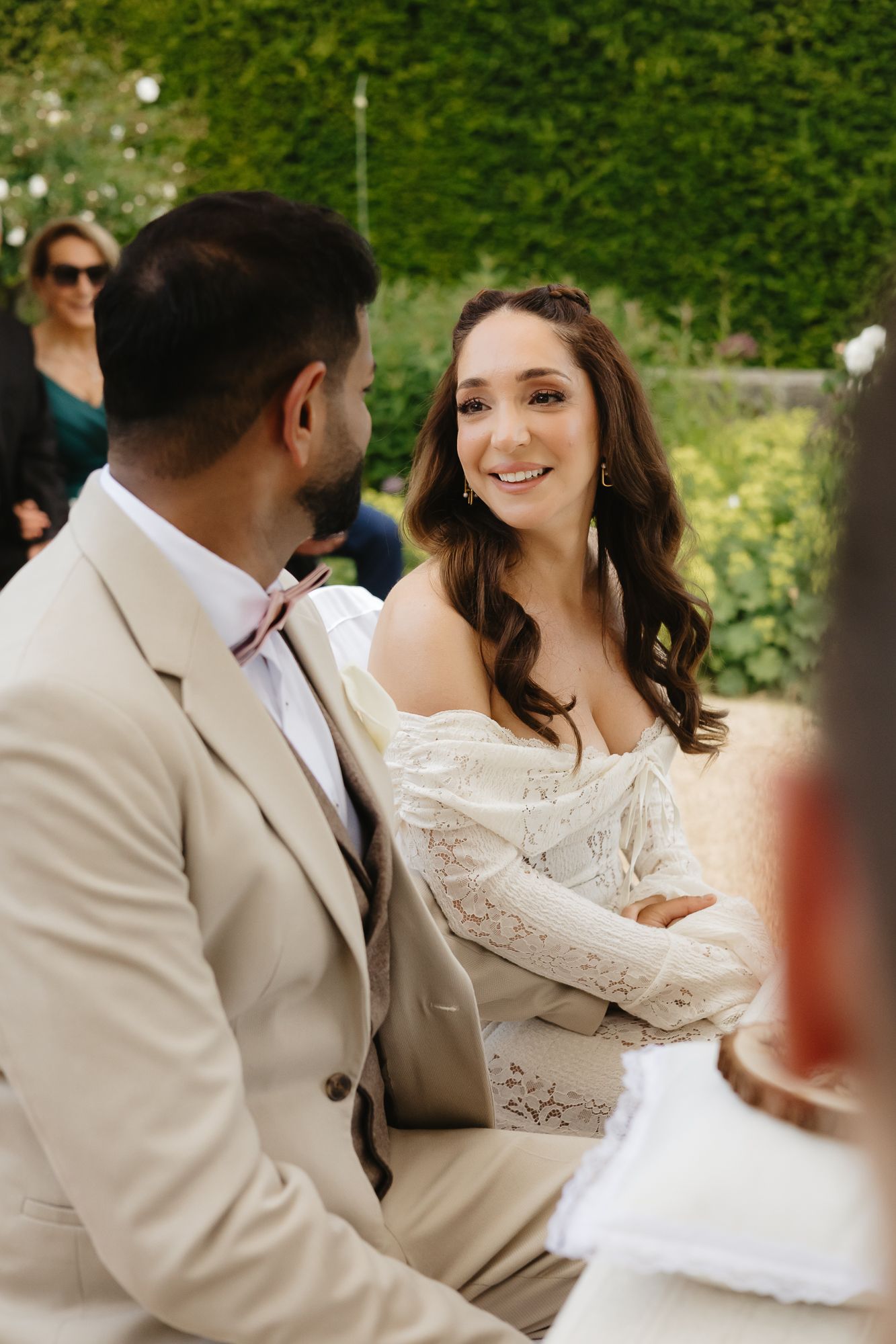 Candid moments captured in an elegant garden setting with white attire.