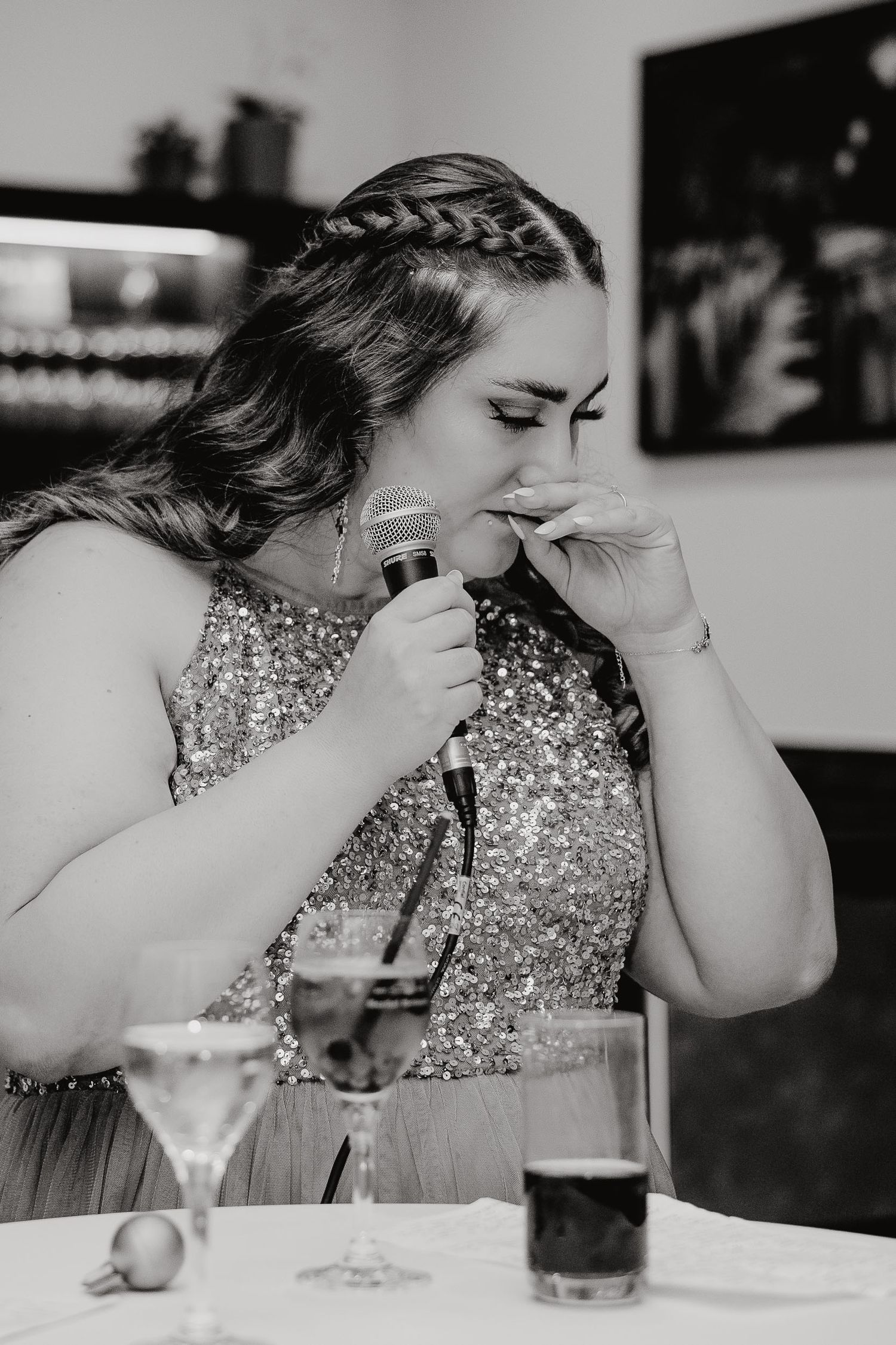 A sequence of photos showing someone in a sparkly dress drinking from a glass at a dining table.