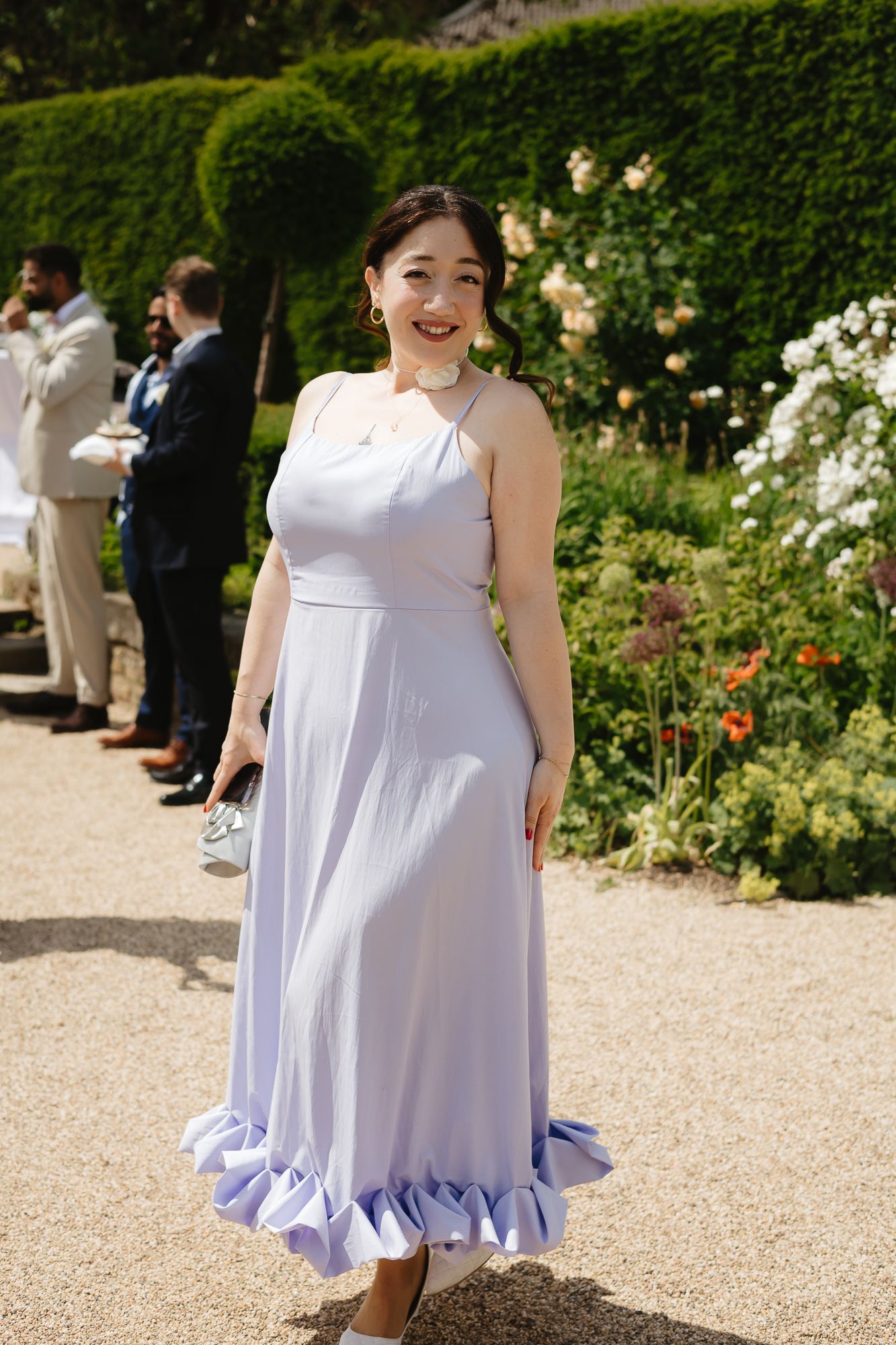 Series of photos showing a flowing lavender dress in a garden setting.