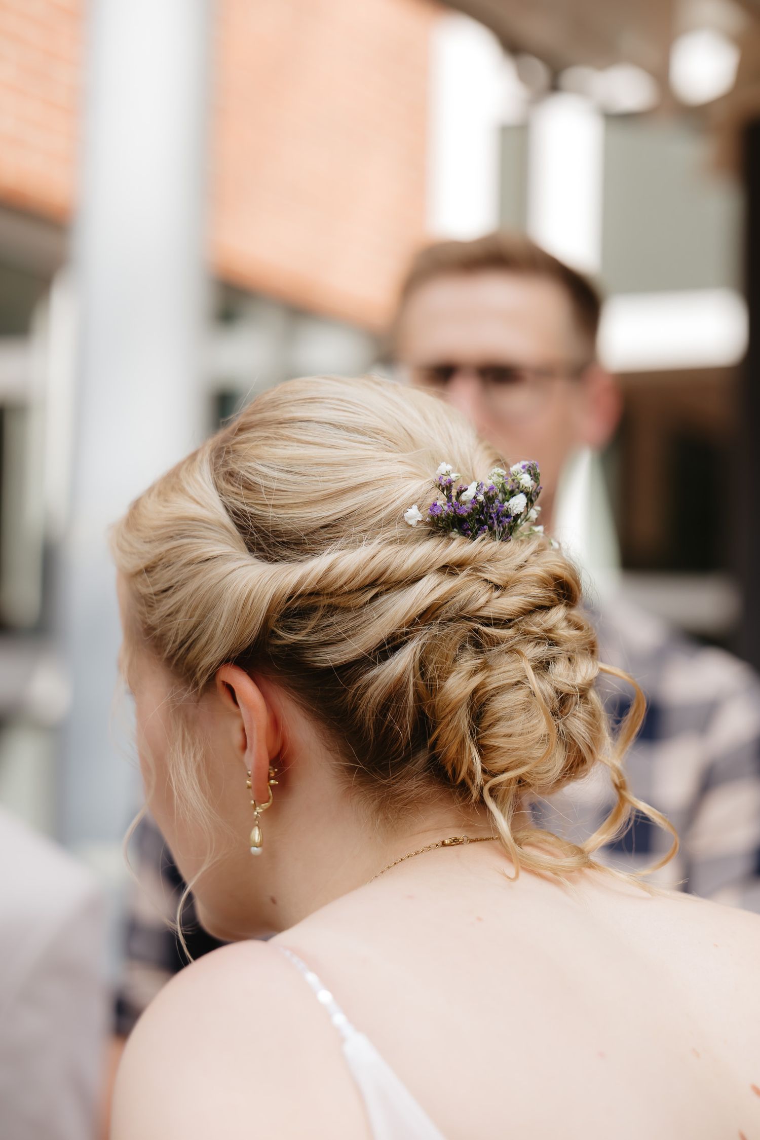 Elegant bridal updo hairstyle with delicate purple floral accessories shown from multiple angles.