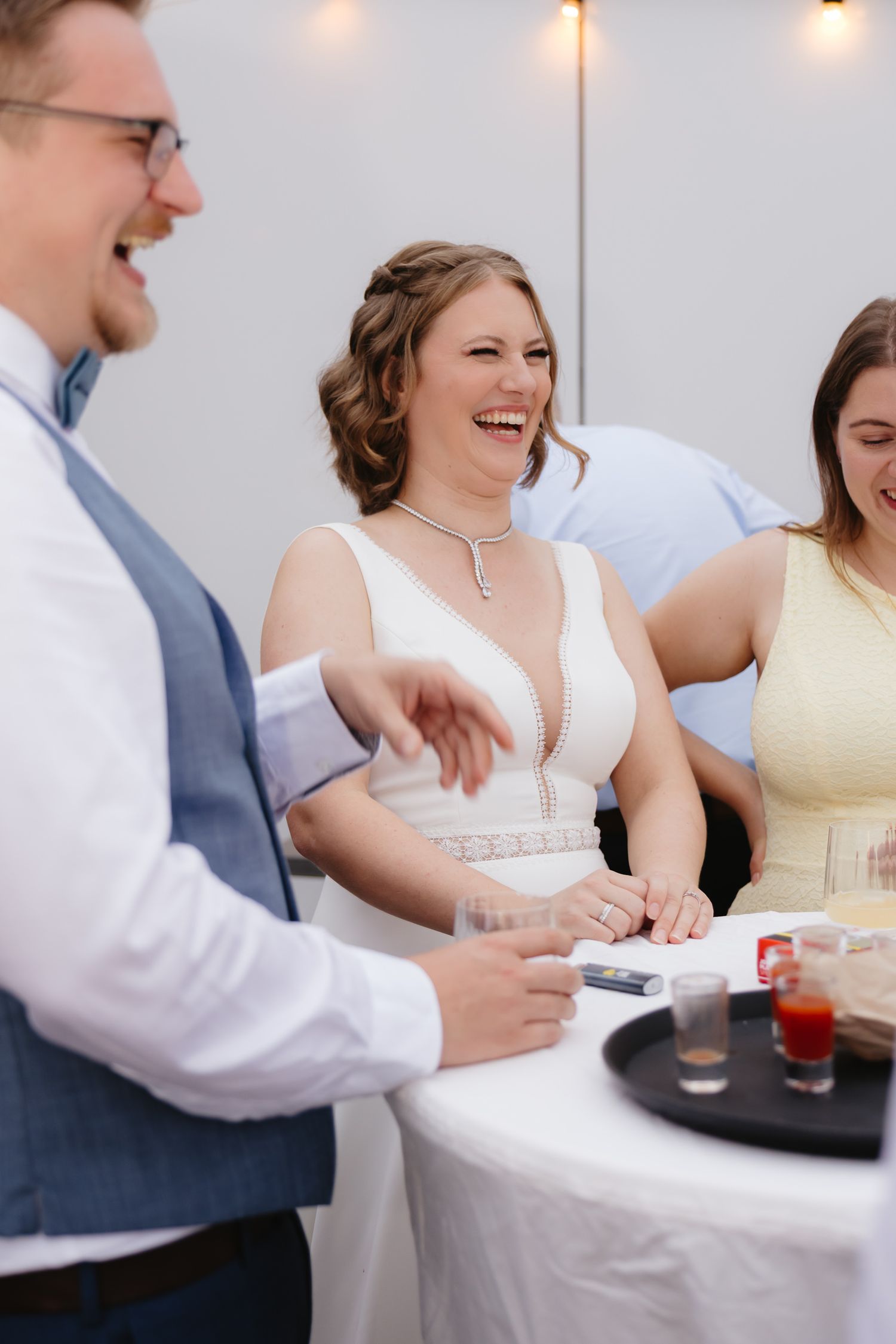 Wedding reception guests sharing laughter and conversation around a table during dinner service.