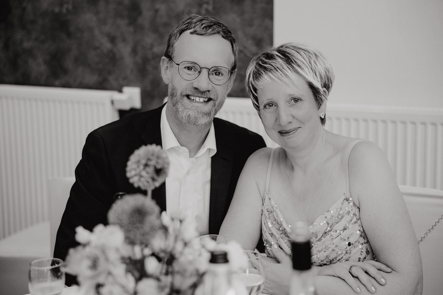 Black and white collage of wedding moments showing couples embracing and laughing during their reception celebration.