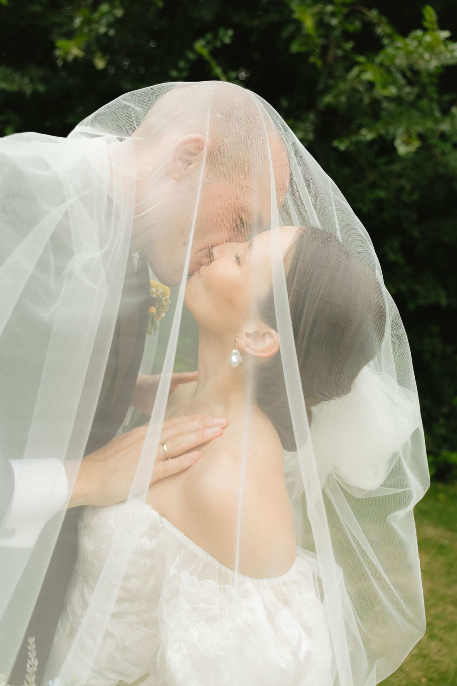 Ethereal bridal portrait through delicate white wedding veil.