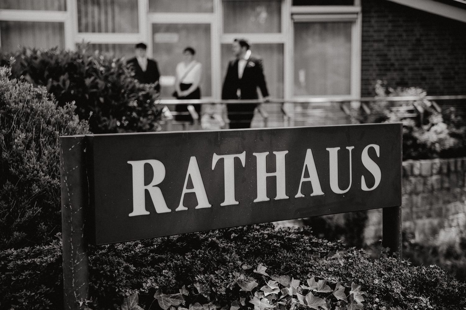 A black and white vintage photograph shows a traditional German Rathaus (town hall) building exterior with architectural details.