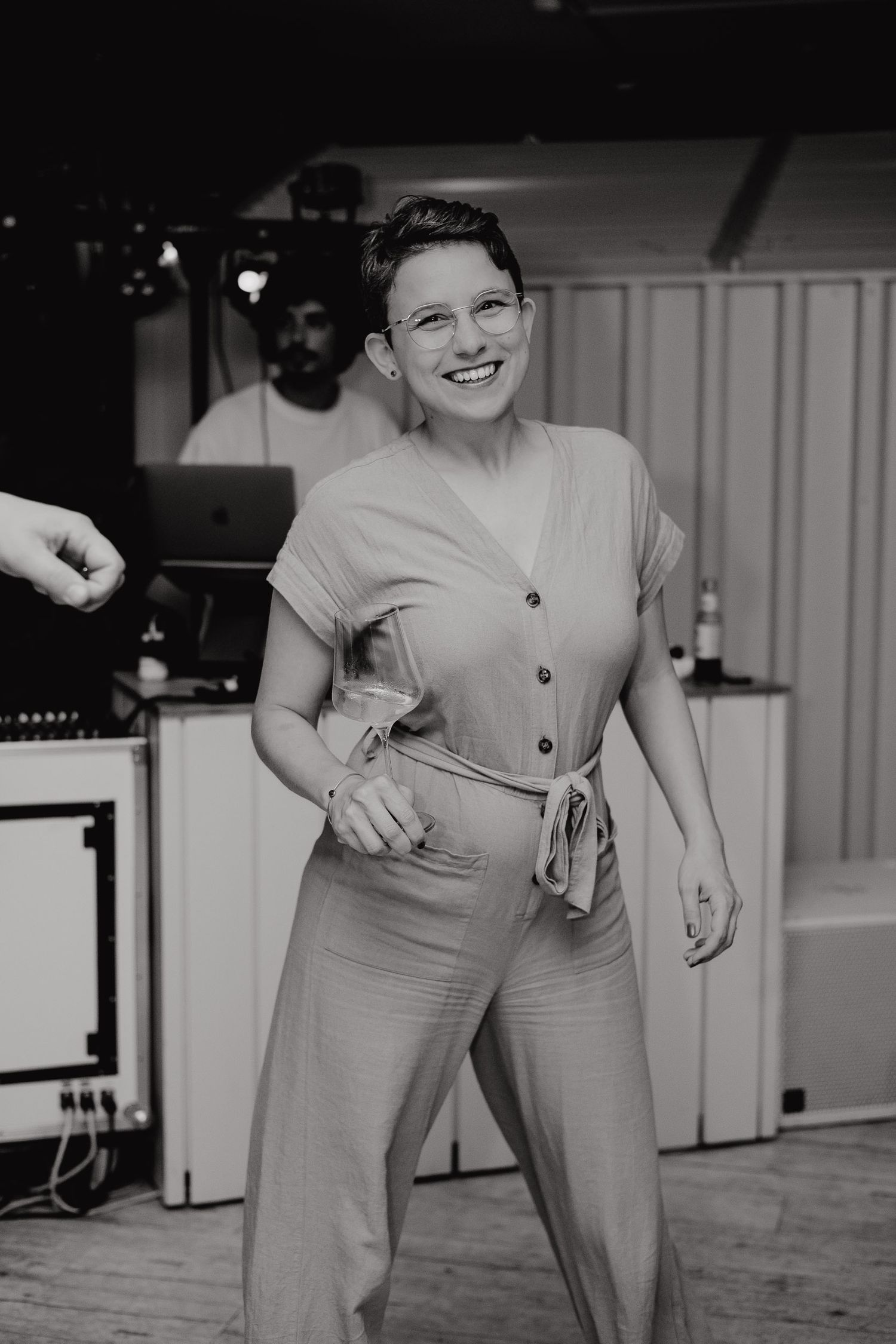 A black and white vintage photograph shows someone in a light-colored button-up blouse and high-waisted pants.