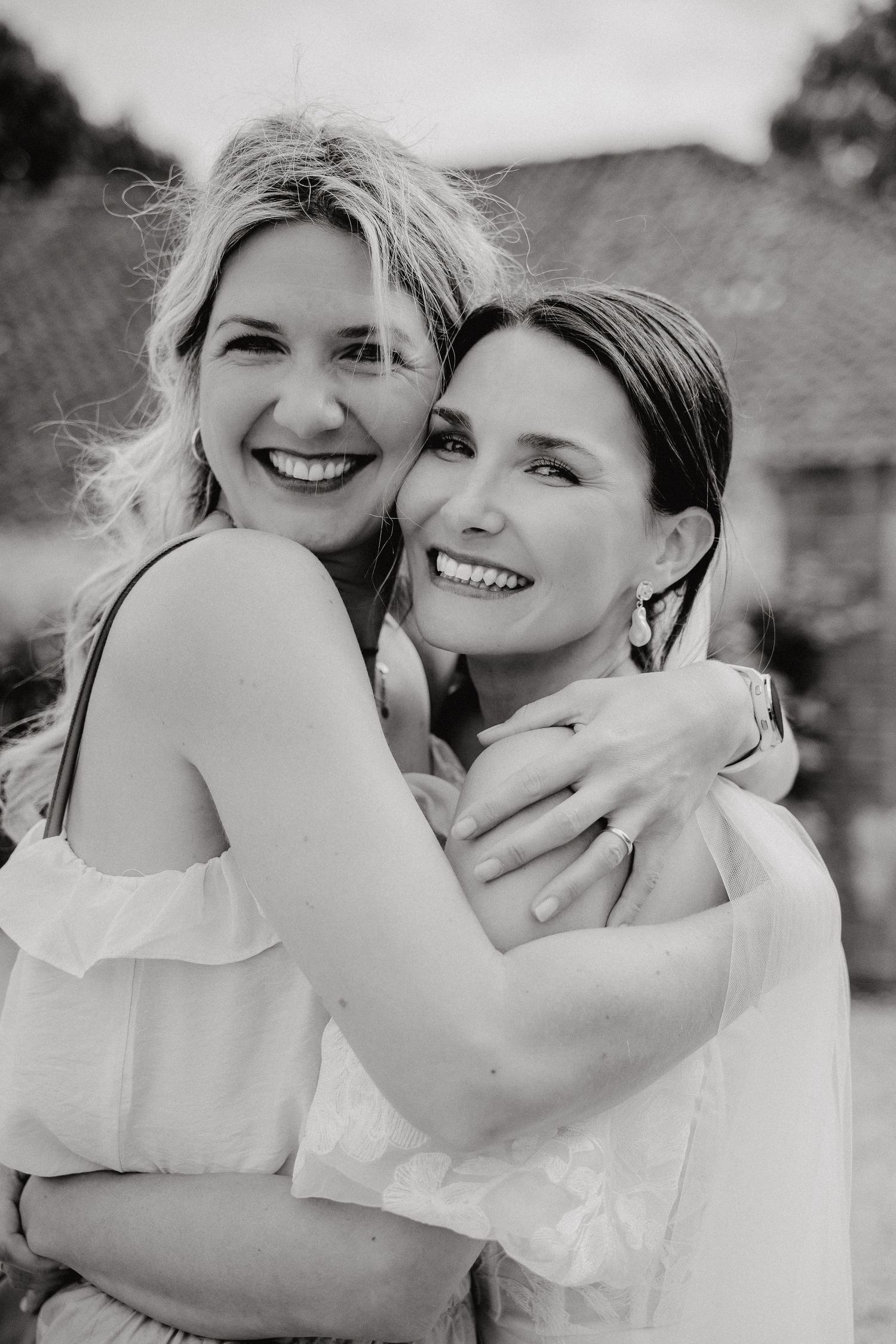 Black and white portrait series showing joyful embraces and candid moments at a wedding celebration.