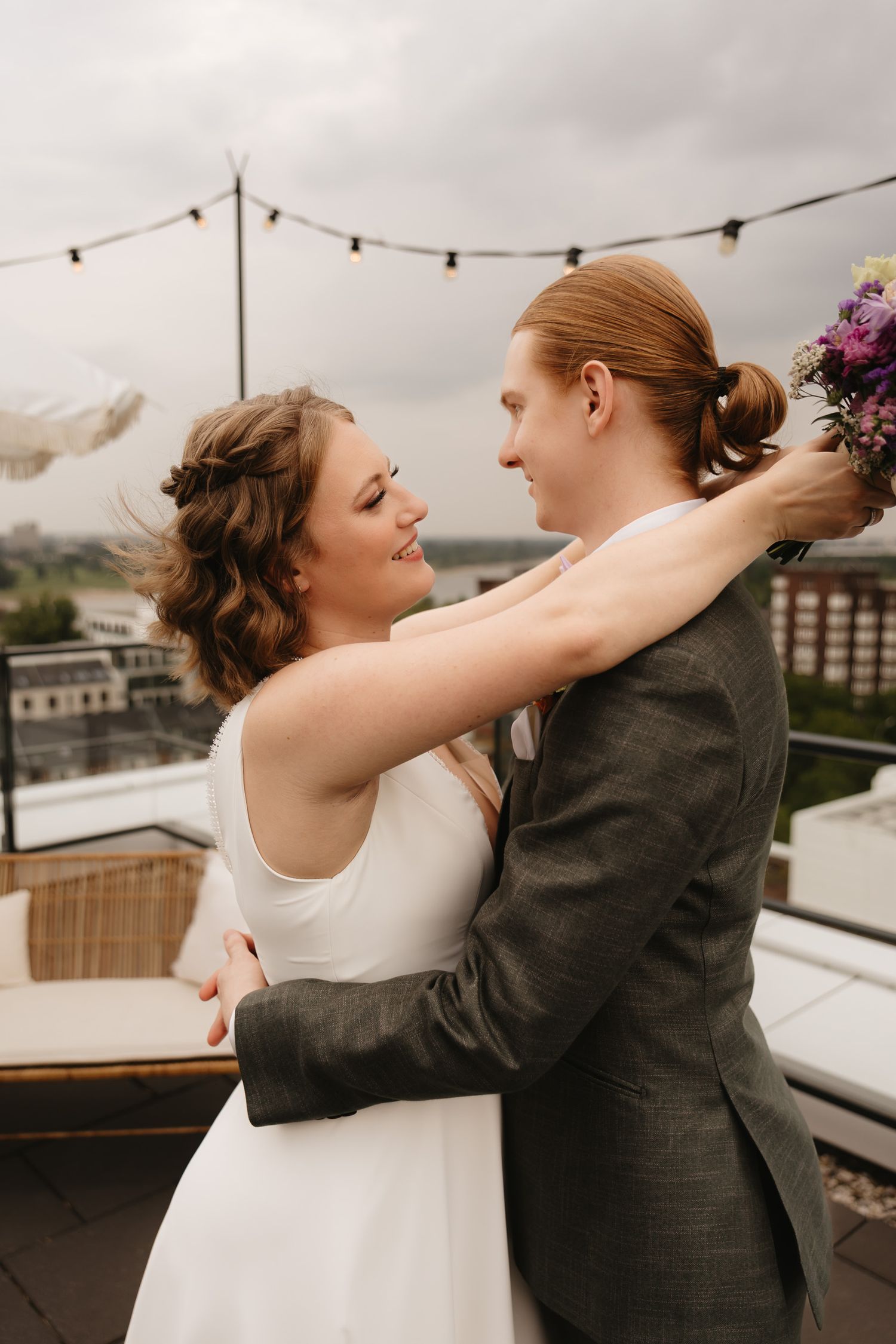 A couple shares a romantic dance together on a rooftop terrace during their wedding celebration.