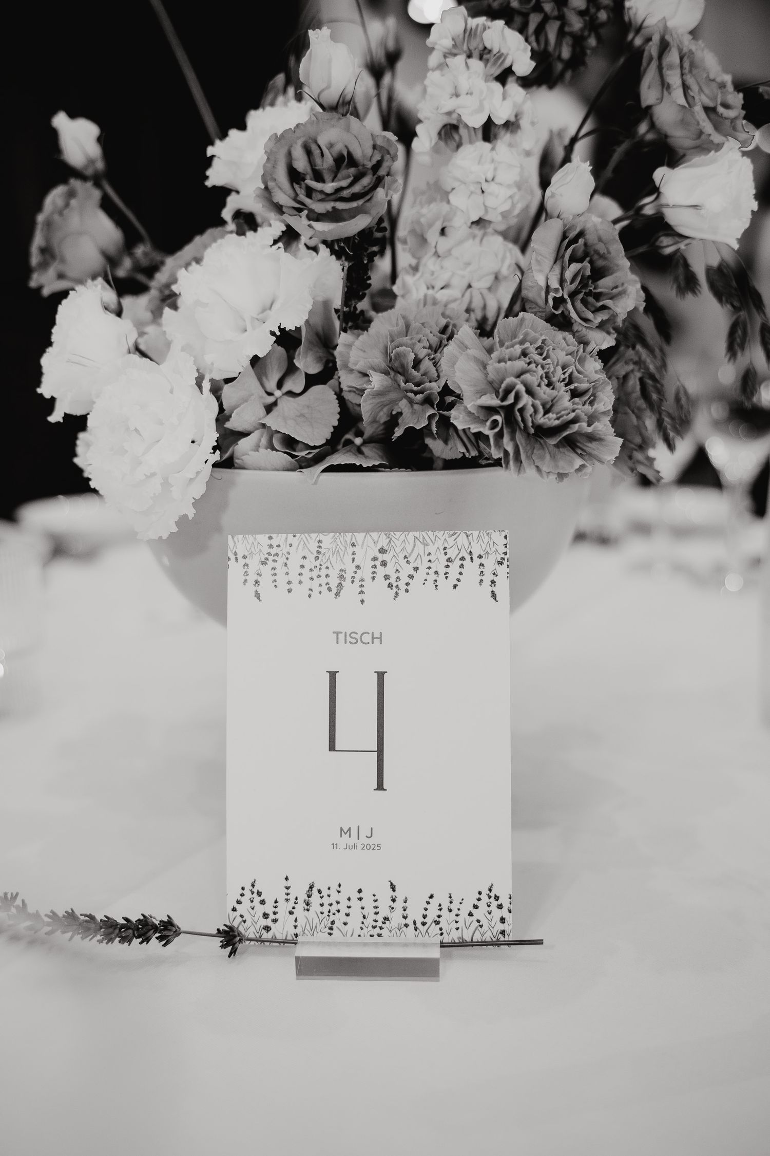 Black and white wedding reception table numbers with floral arrangements and decorative cards.