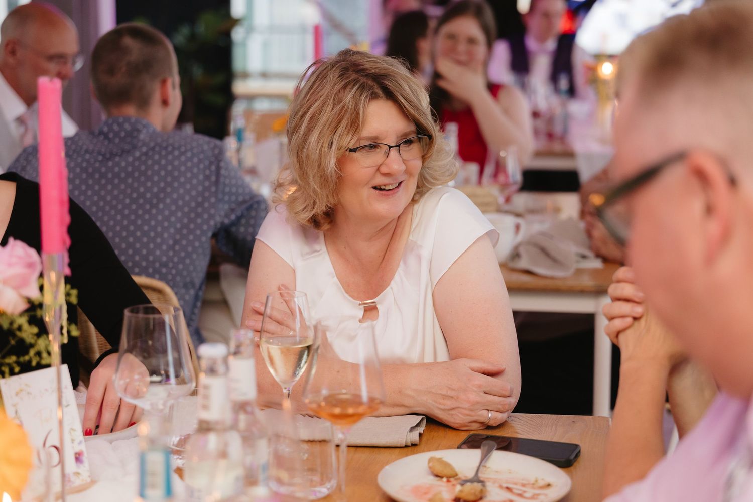 People enjoying a lively conversation around a dining table at what appears to be a social gathering or event.