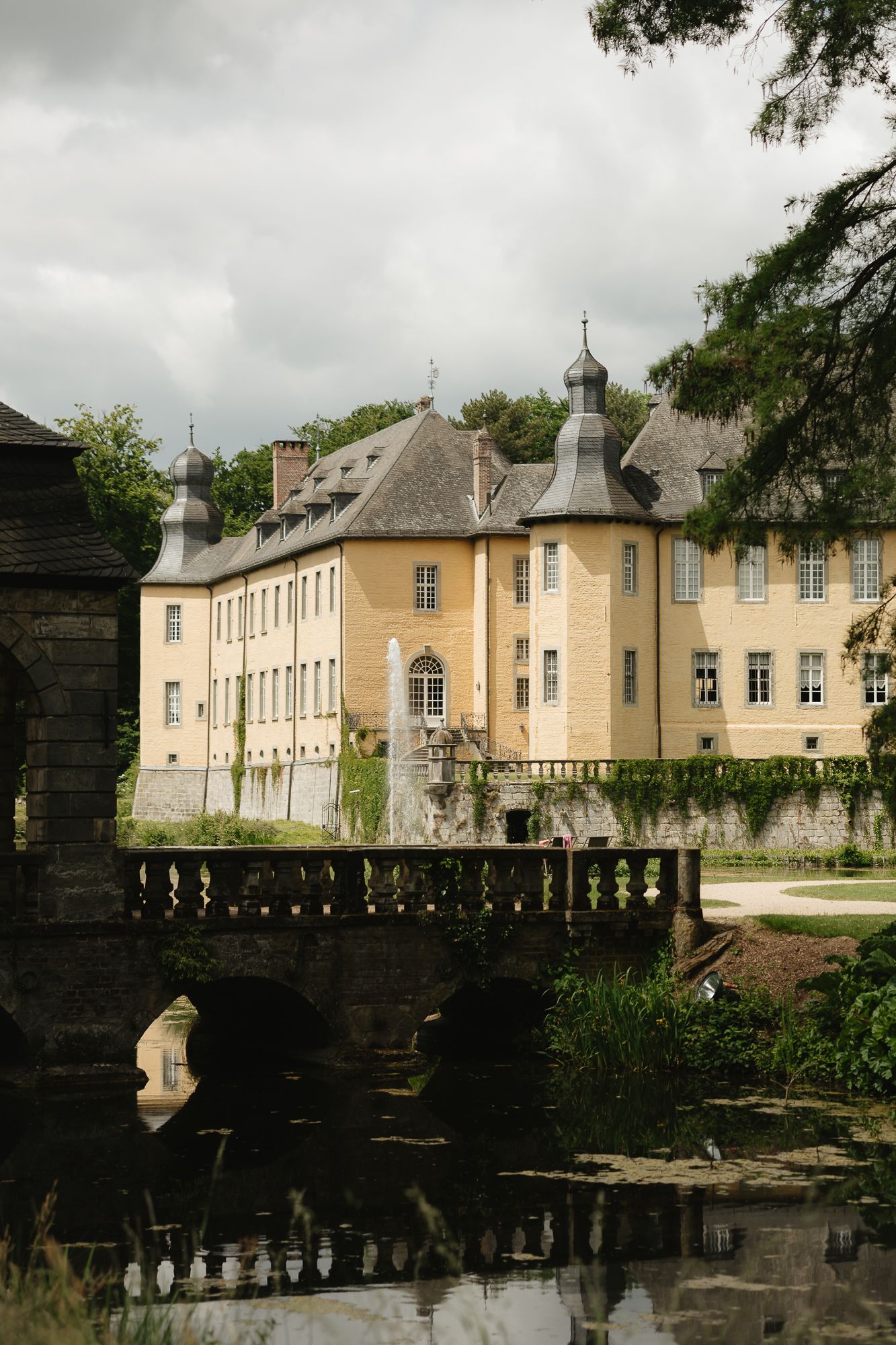 Historic yellow chateau with classic architecture reflected in still waters.